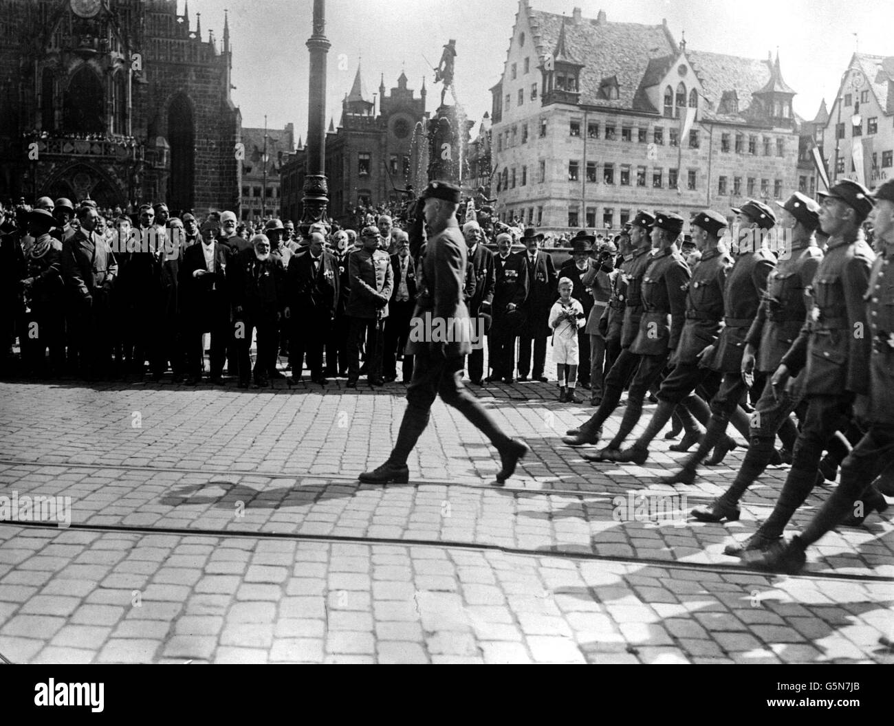 1923: Stosstruppen marschieren am 'Großen Deutschen Tag' in Nürnberg, Bayern, vorbei an ihrem Führer, Adolf Hitler (2. Links, Trenchcoat), Politikern und bayerischen Mitgliedern der ehemaligen deutschen Reichsarmee. Schätzungsweise 100,000 Personen haben an der Veranstaltung teilgenommen. Stockfoto