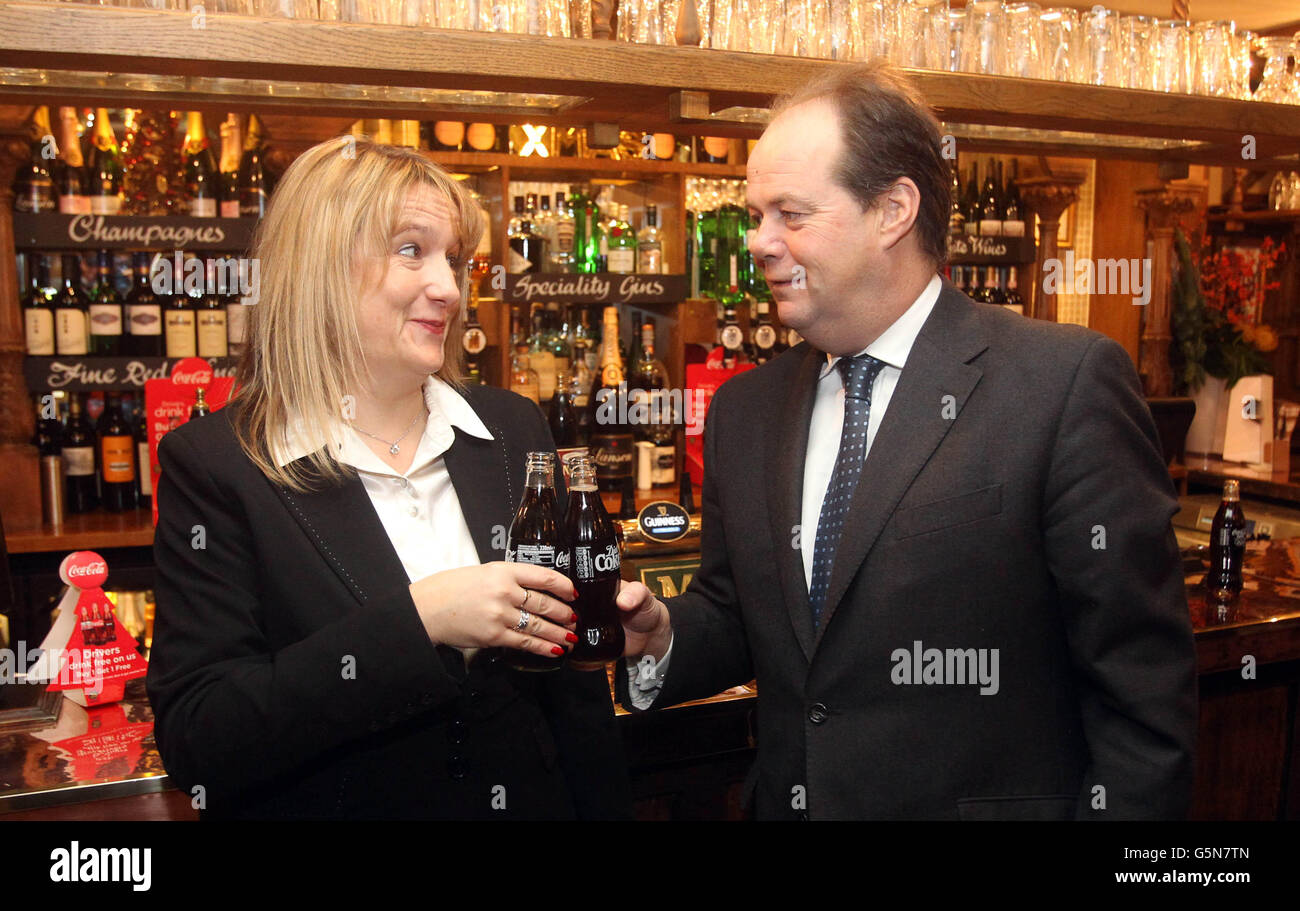 Der Abgeordnete Stephen Hammond, Minister für Straßenverkehrssicherheit, mit dem Vertreter von Coca Cola Kerry Roberts bei The Masons Arms in London, um eine Kampagne zu starten, bei der designierte Fahrer über Weihnachten „zwei zum Preis von einem“-Angebote für Coca-Cola erhalten. Stockfoto