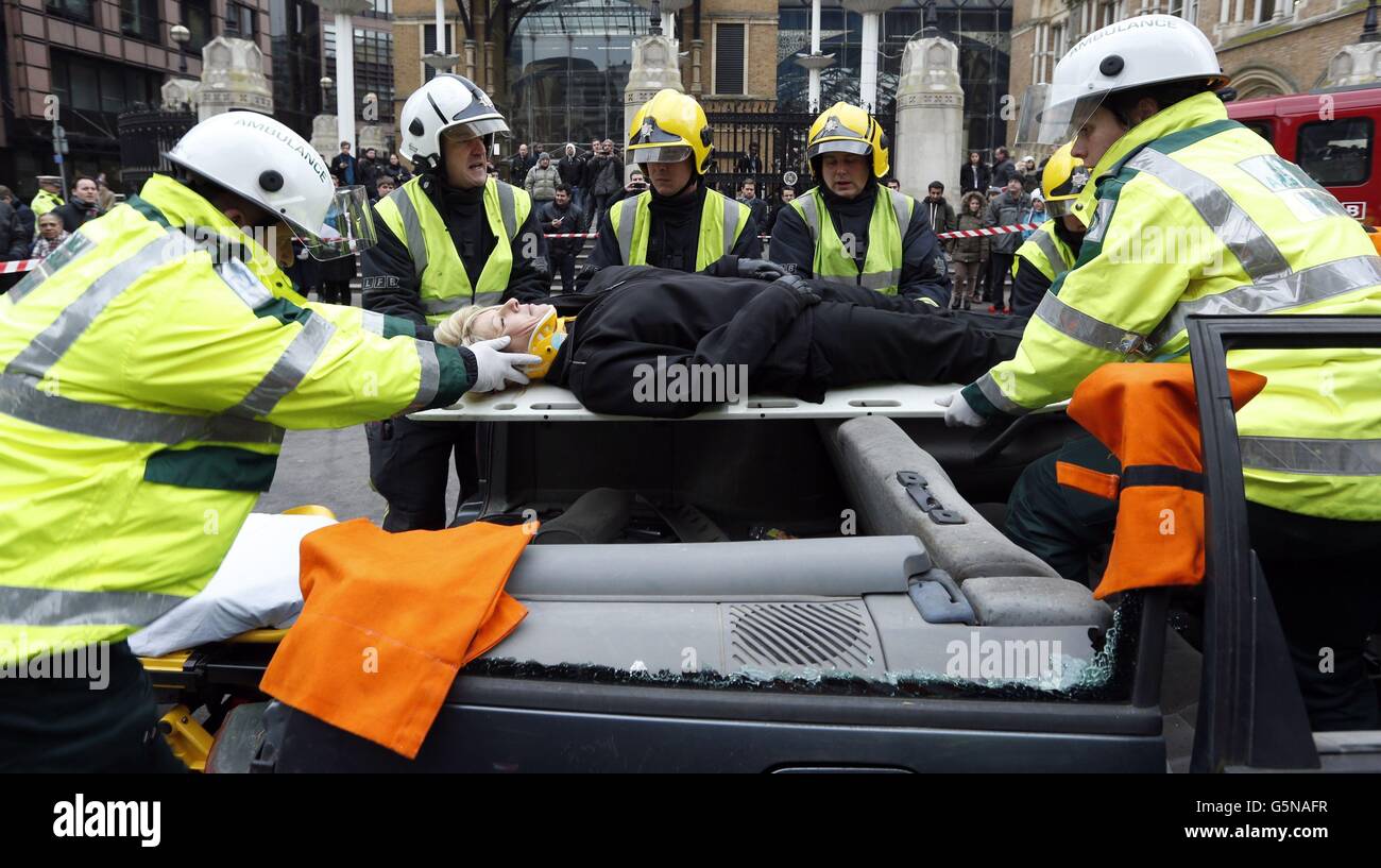 Mitglieder des City of London Road Safety Team, der Londoner Feuerwehr und des City of London Ambulance Service starten eine Anti-Drink-Fahrkampagne, indem sie die Entfernung eines Opfers bei einem Autounfall vor dem Bahnhof Liverpool Street in London simulieren. Stockfoto