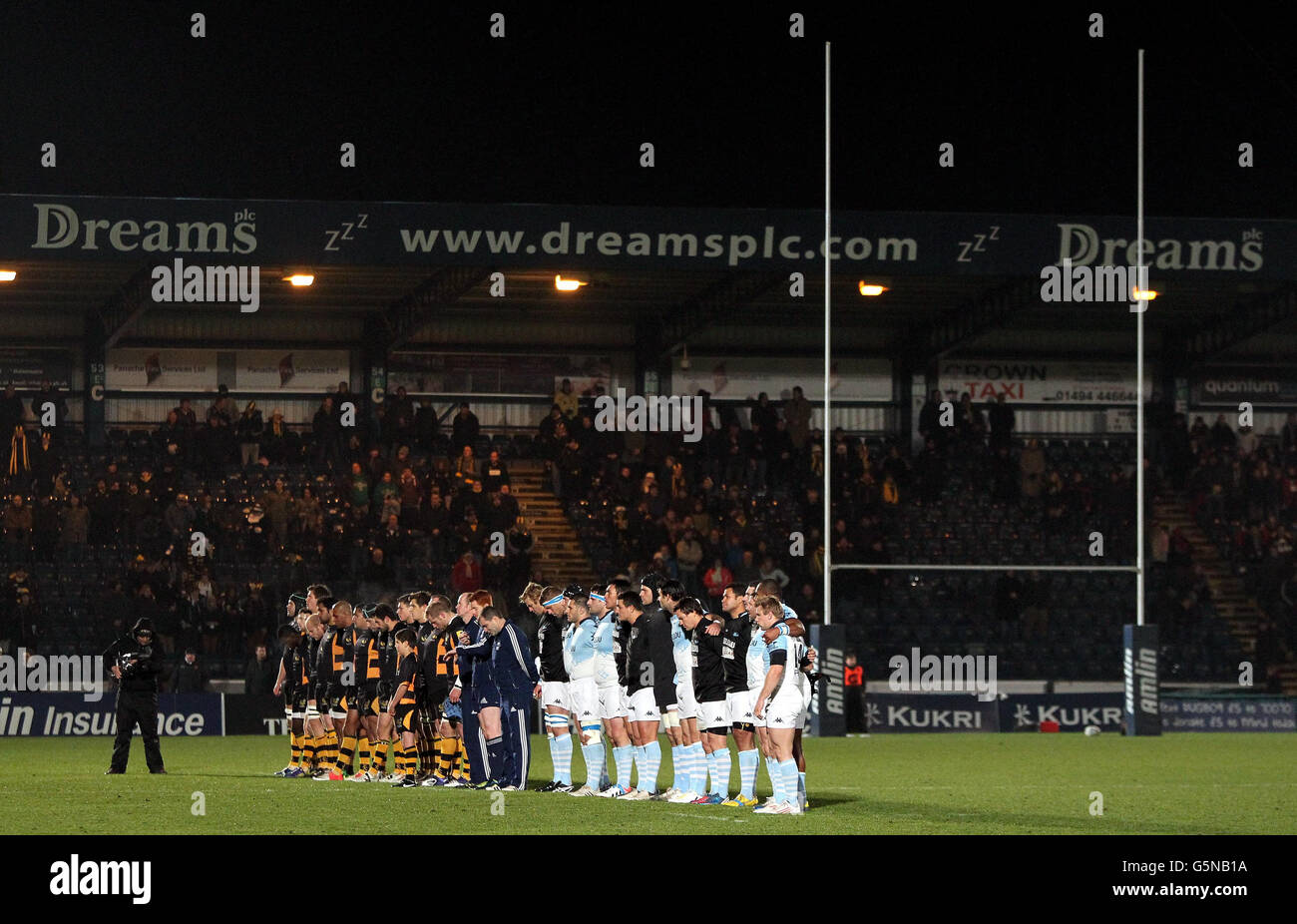 Spieler von Wesps und Bayonne während eines Moments Stille in Erinnerung an den ehemaligen Sale-Spieler David Tait, der während des Amlin Challenge Cup-Spiels im Adams Park, Wycombe, aus einem Wohnblock in Hongkong gefallen ist. Stockfoto