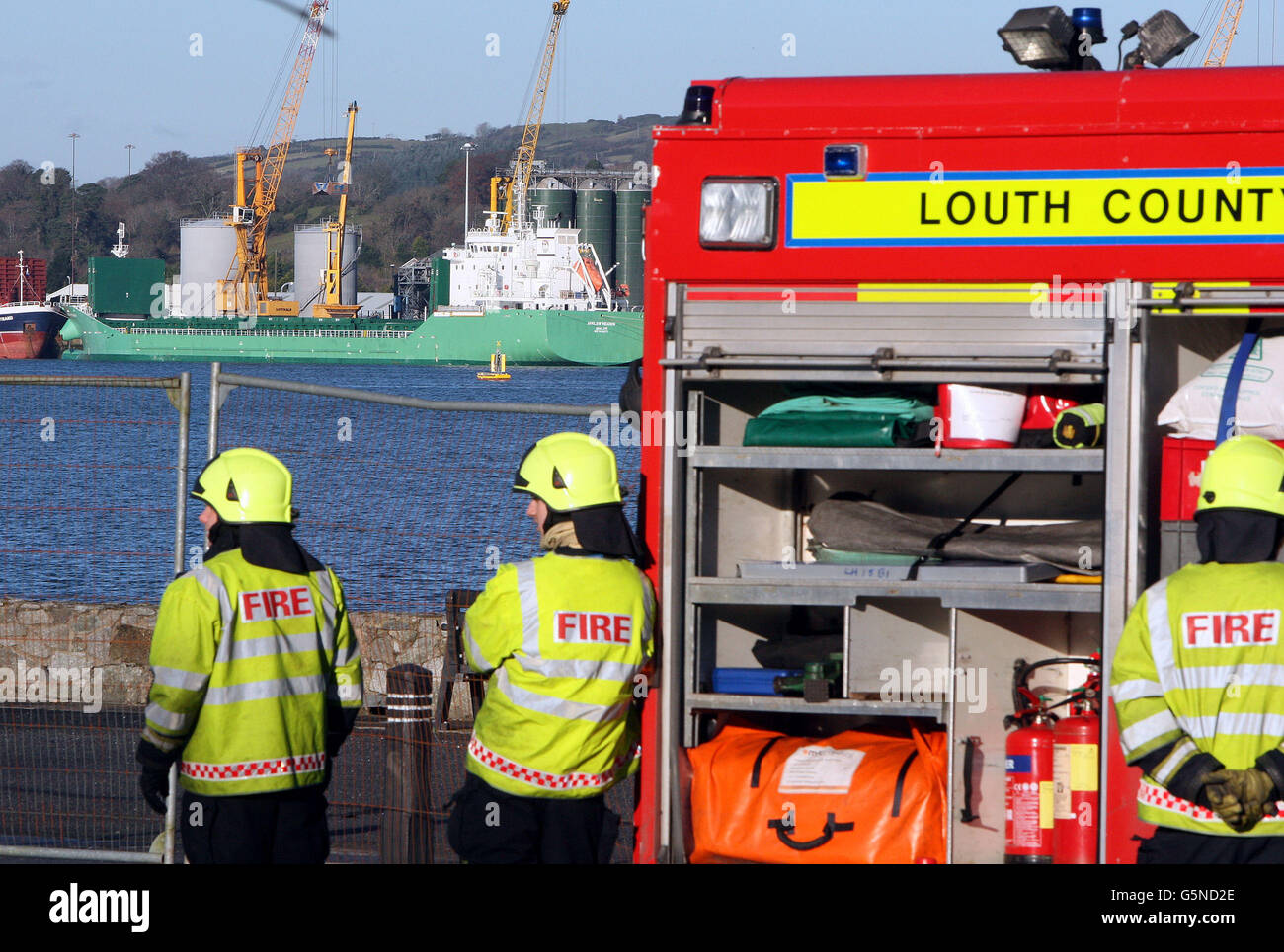 Feuerwehrleute aus Omeath in Co Louth überwachen die MV Arklow Meadow, die im Hafen von Warrenpoint in Co Down nach 18 Personen behandelt wurde, nachdem Giftgas zum Töten von Nagetieren aus dem Schiff verwendet wurde. Stockfoto