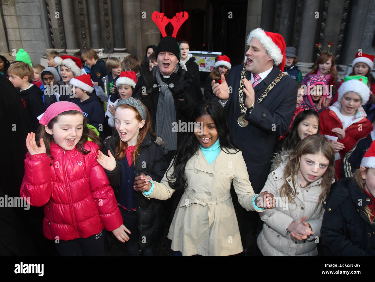 Rev David Gillespie (links) und Lord Mayor Naoise O Muiri schließen sich Kindern der Kildare Place National School an, um den jährlichen sieben Tage langen Black Santa Charity Sit Out Appell in der St Ann's Church Dublin, Irland, zu starten. Stockfoto