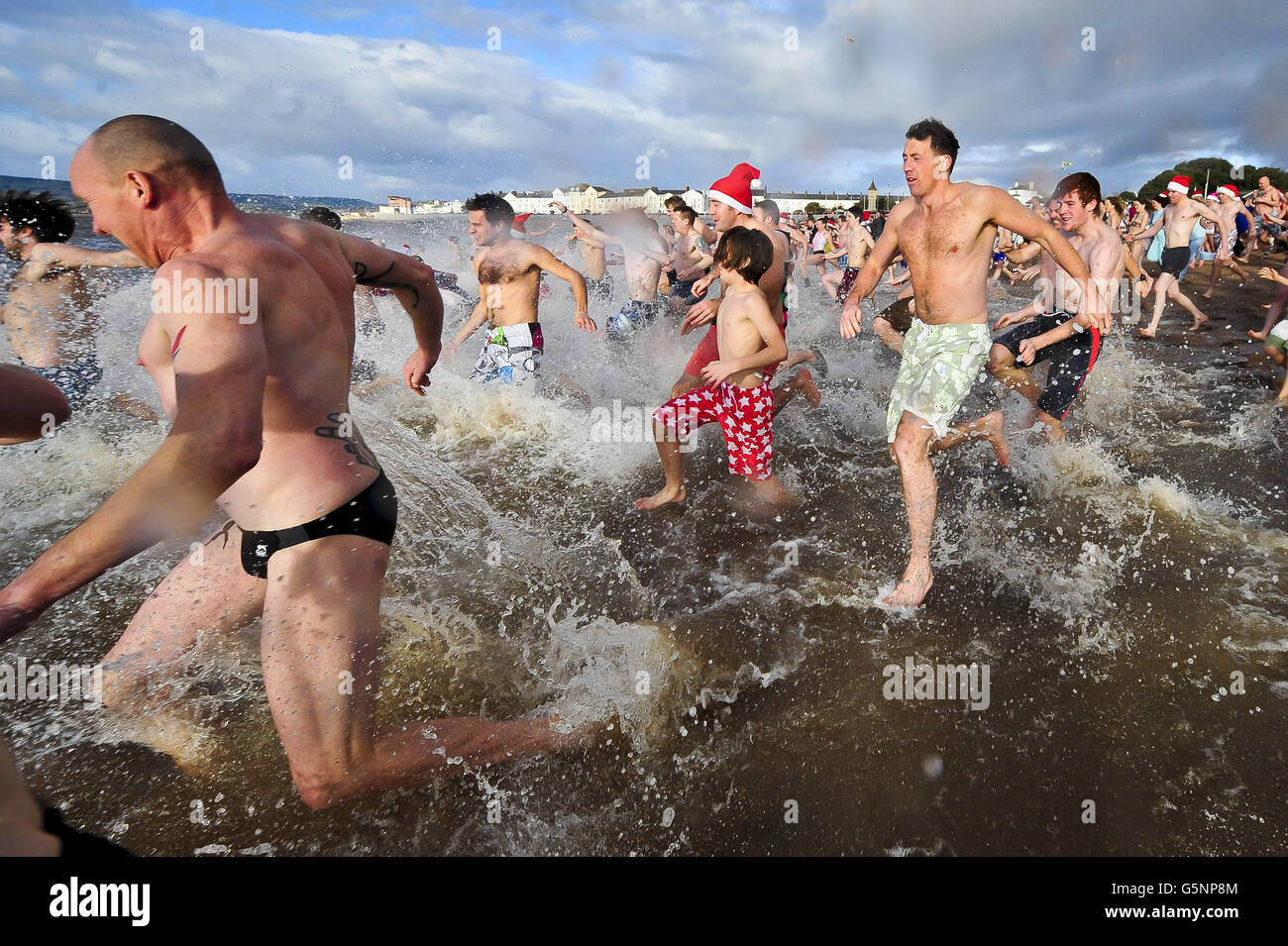 Schwimmer gehen zum Meer in Exmouth für das jährliche Schwimmen am Weihnachtstag. Stockfoto