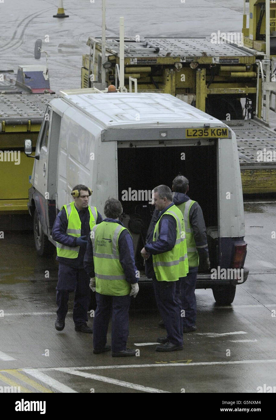 Flughafenmitarbeiter stehen am Flughafen Heathrow in der Nähe eines Transporters, der den für den sicheren Transport verwendeten Van ähnelt. Räuber haben einen Sicherheitswagen überfallen und sind mit Millionen von Dollar geflogen, von denen man weiß, dass sie mit einem Jet aus Bahrain in den Flughafen geflogen wurden. * ... und zum New Yorker Flughafen JFK. Der Fahrer des Transporters wurde von mindestens zwei Räubern angehalten, die das Geld dann an einen anderen Transporter überwiesen, der in der Nähe des Flughafens ausgebrannt gefunden wurde. Stockfoto