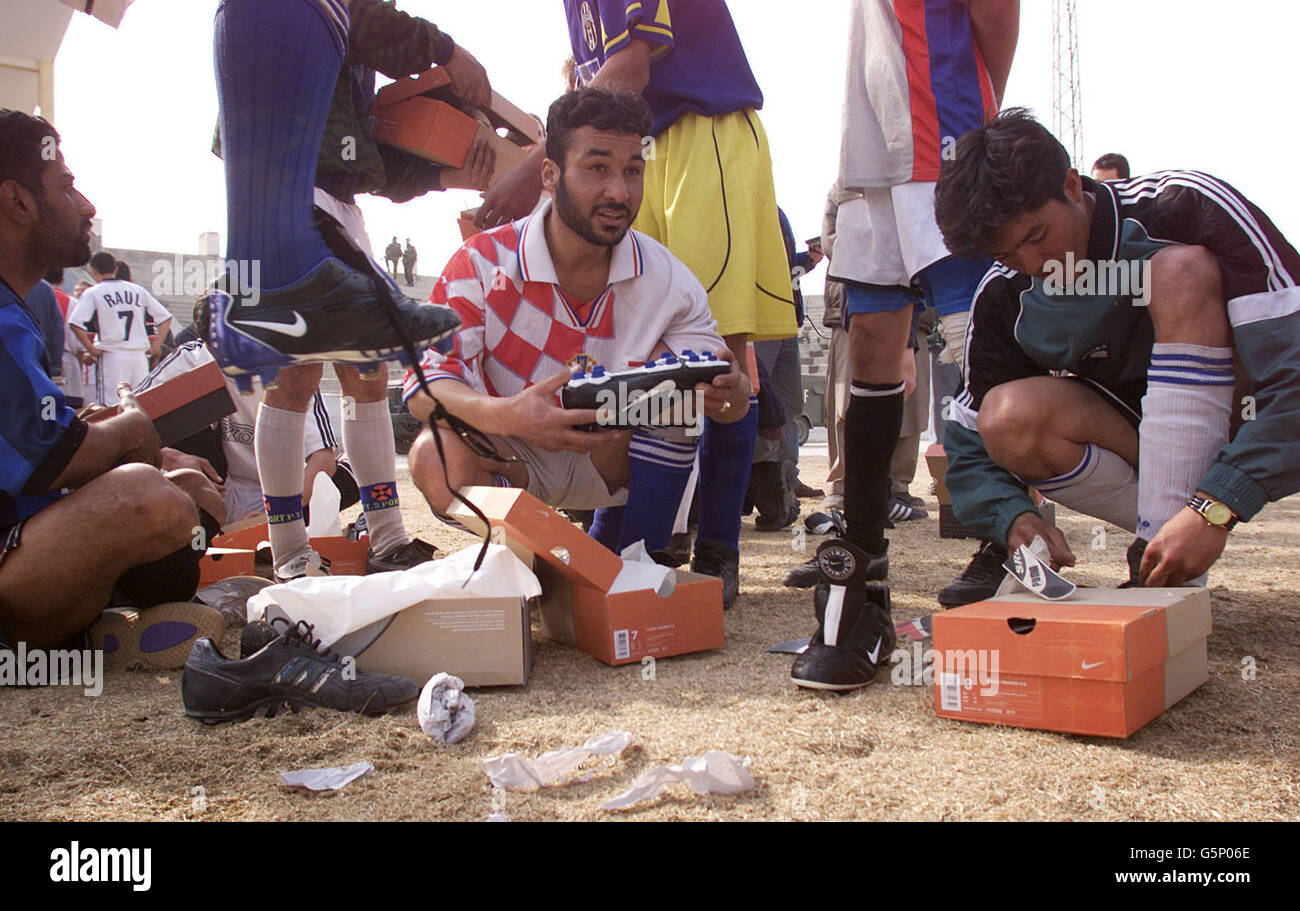 Die Spieler des FC Kabul öffnen die neuen Stiefel, die ihnen der Fußballverband und Barclaycard im Olympiastadion in Kabul, Afghanistan, gegeben haben. Lawrie McMenemy und Gary Mabbutt sind in dem vom Krieg zerrissenen Land, um die Seite und ein Armeeteam aus Soldaten der ISAF (International Security Assistance Force) aus Großbritannien, Italien, Deutschland und Holland für ein Spiel morgen zu trainieren. Das Olympiastadion ist berüchtigter für die Hinrichtungen, die dort vom ehemaligen Taliban-Regime abgehalten wurden, als für seine Sportereignisse. Stockfoto