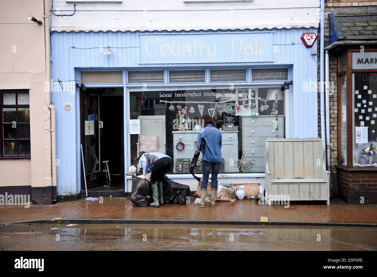 Nach einer schweren Überschwemmung in Braunton, North Devon, haben Menschen durch klares Wasser Gegenstände aus Geschäften beschädigt. Stockfoto