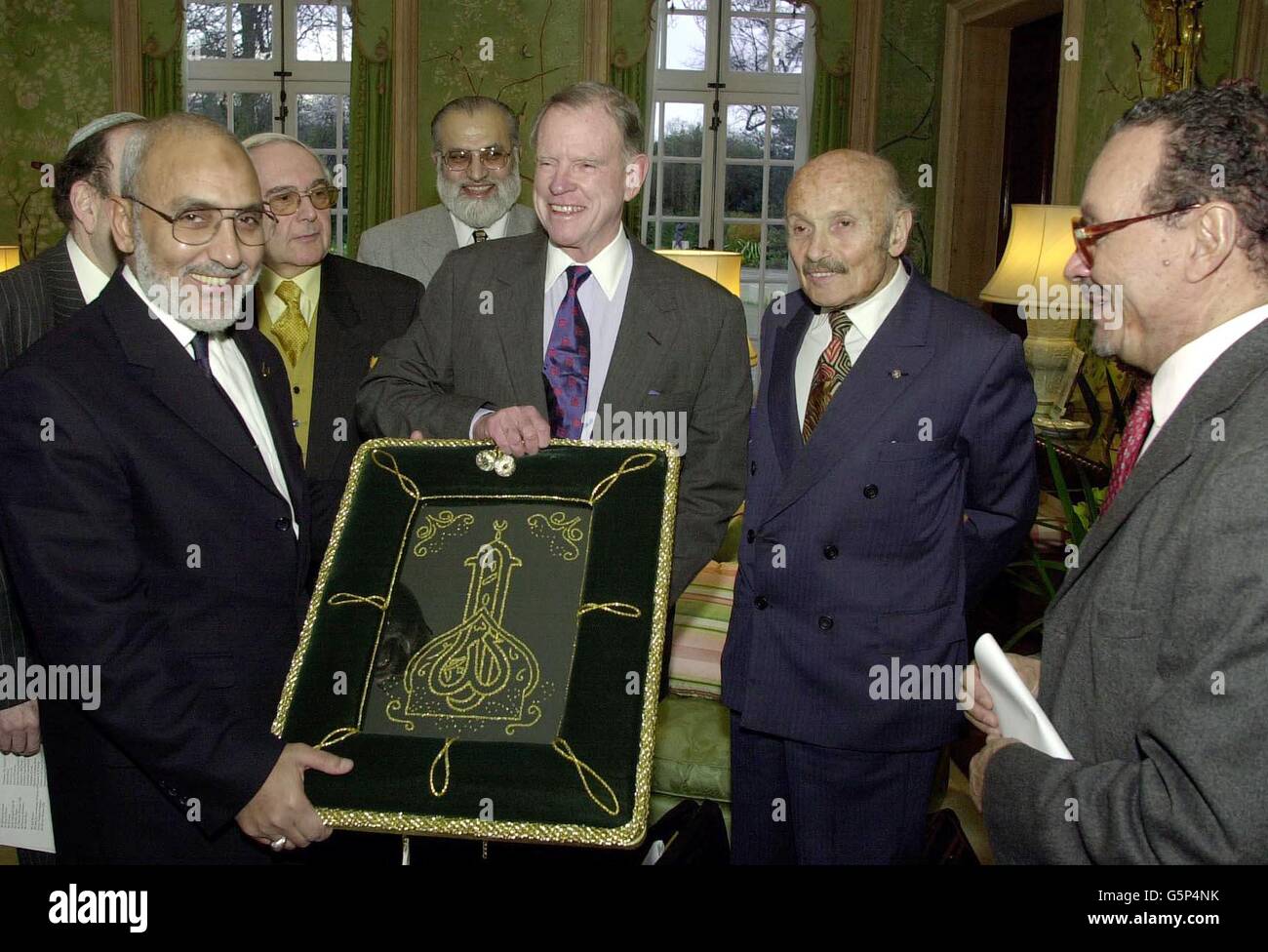 Der US-Botschafter in Großbritannien, William Farish (3. Rechts), nimmt einen islamischen Wandteppich von Dr. Hani El-Banna (links) an, der von Sir Sigmund Sternberg (2. Rechts) und Scheich Dr. Zaki Badawi (rechts) in seiner Londoner Residenz beobachtet wird. * der Botschafter unterhielt Mitglieder des britischen Forums für drei Glaubensrichtungen, das die christlichen, jüdischen und muslimischen Gemeinschaften im ganzen Land vertritt, und suchte nach Harmonie zwischen ihnen nach den Terroranschlägen vom 11. September letzten Jahres in Amerika. Stockfoto