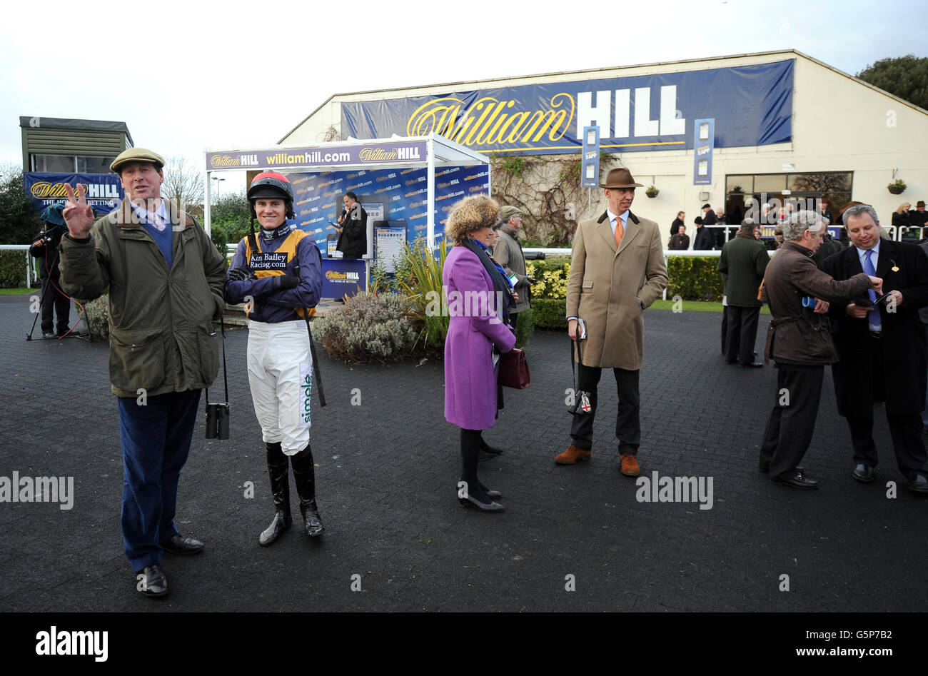 Pferderennen - William Hill Winter Festival - Tag Zwei - Kempton Park Racecourse. Ein allgemeiner Blick auf Jockeys und Trainer im Paradering auf der Rennbahn Kempton Park Stockfoto