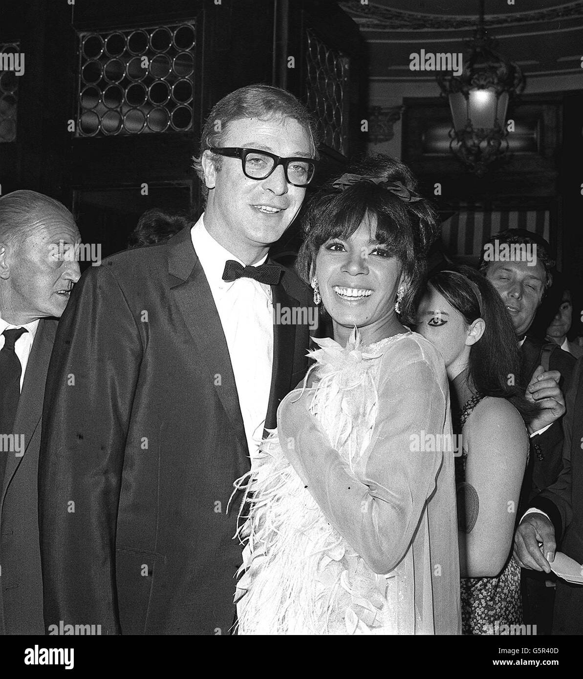 Michael Caine, Star des Films, mit Shirley Bassey, der Sängerin, bei der Gala-Premiere von Otto Premingers 'Hurry Sundown' im Plaza Theatre, London. Stockfoto