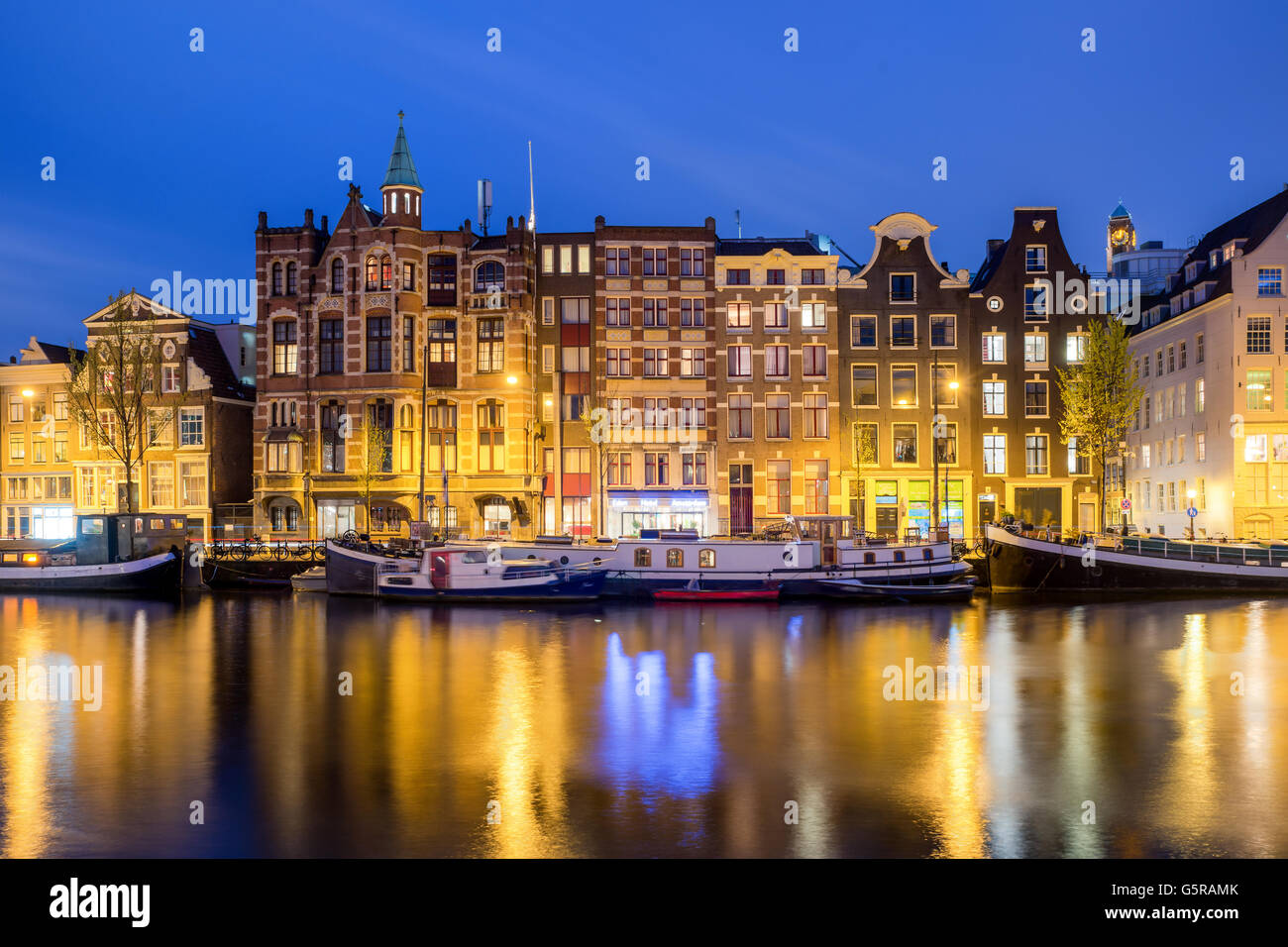 Traditionelle niederländische Häuser in der Nacht in Amsterdam, Niederlande. Stockfoto