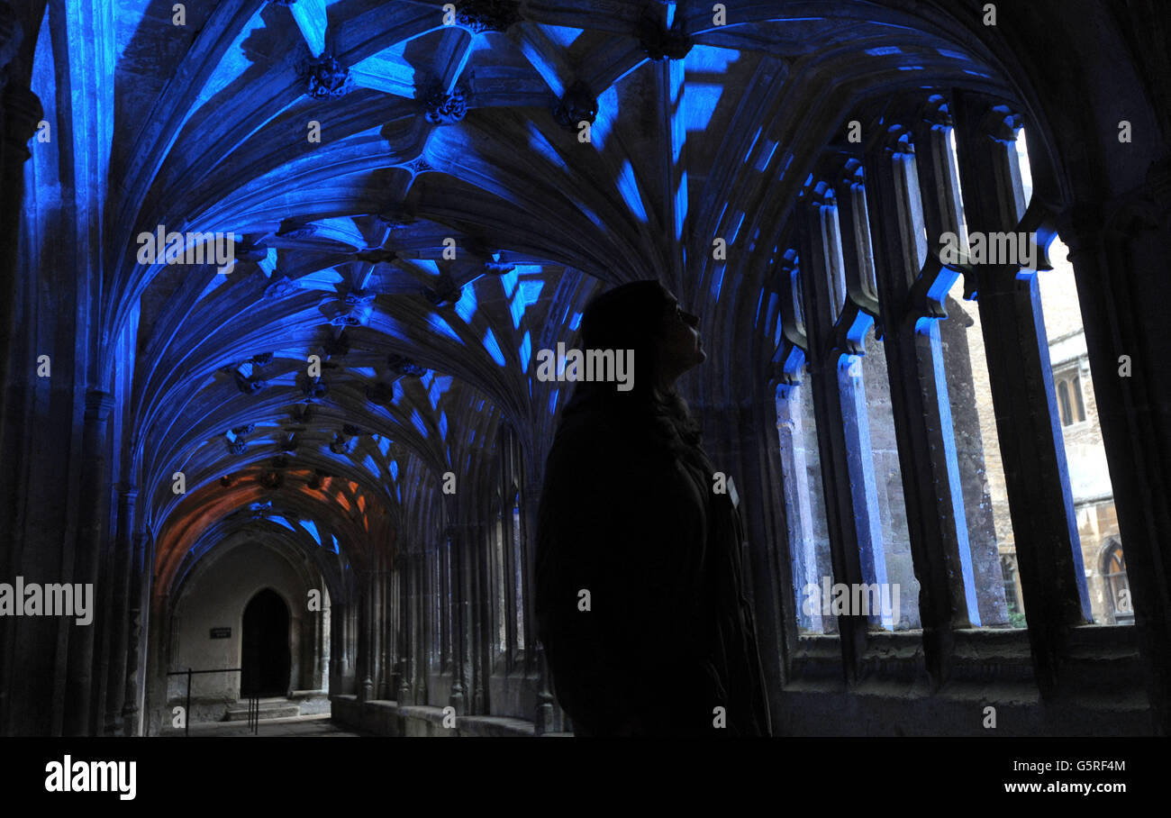 Die Volontärin des National Trust Kristine Heuser blickt auf den Kreuzgang in der Lacock Abbey, wo Szenen aus Harry Potter gedreht wurden, die von Lichtspezialisten für das Illuminating Lacock Festival in Wiltshire beleuchtet wurden. Stockfoto