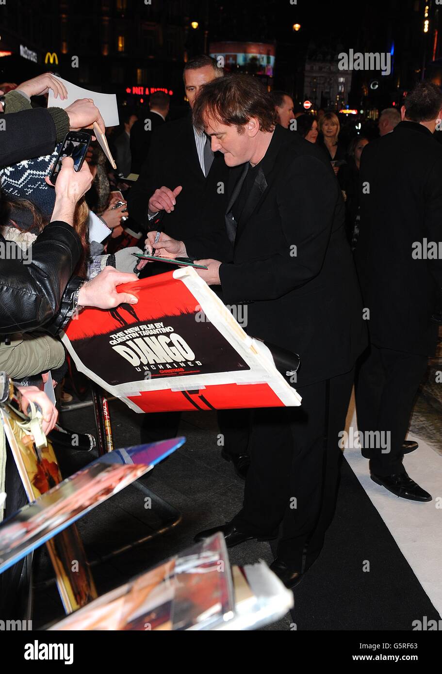 Regisseur Quentin Tarantino gibt Autogramme für Fans, als er zur Premiere von Django Unchained am Empire Leicester Square in London ankommt. Stockfoto