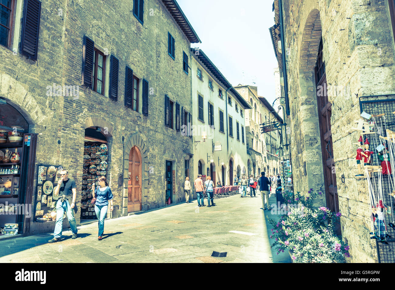 Alten verblichenen Farben Bildeffekt von Touristen in der schmalen Straße italienische Toskana ummauerten Stadt San Gimignano Stockfoto