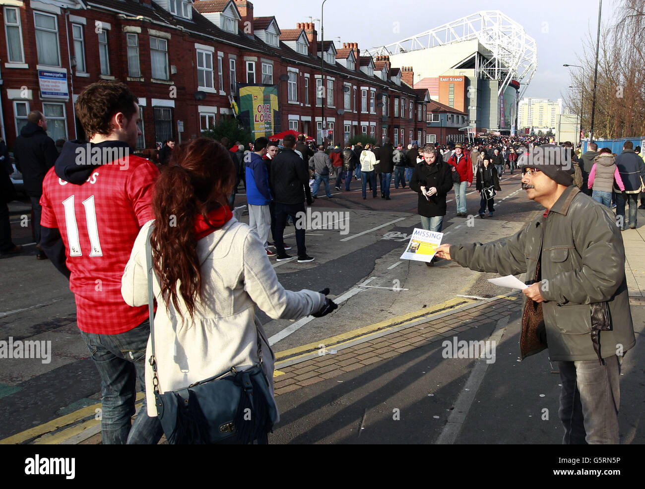 Santanu Pal, Vater des vermissten indischen Studenten Souvik Pal, verteilt Flugblätter an Fans, die sich auf dem Weg zum Fußballspiel zwischen Manchester United und Liverpool im Old Trafford Stadium von United in Manchester befinden. Stockfoto