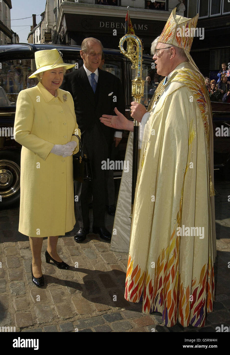Die britische Königin Elizabeth II. Und der Herzog von Edinburgh (Mitte) werden vom Erzbischof von Canterbury, Doktor George Carey, in der Kathedrale von Canterbury zu einem königlichen Maunday-Gottesdienst begrüßt. * während des einstündigen Dienstes überreichte die Königin 76 Frauen und 76 Männer - entsprechend ihrem Alter im nächsten Monat - zwei Tüten Grüngeld. In jedem kleinen roten Beutel war eine neue 5-Münze und ein 50p-Stück, das das Jubiläum markiert, während in einem weißen Beutel war 76p im Wert von besonderen Grüngeld. Stockfoto