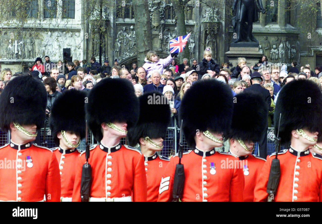Grenadier Guardsmen und Mitglieder der Öffentlichkeit sehen sich an, wie der Sarg der Queen Mother auf dem Weg zur Westminster Abbey im Zentrum Londons vorbeigeht. Königliche Würdenträger und Politiker aus der ganzen Welt haben sich in der Westminster Abbey versammelt, um der Königinnen-Mutter ihren Respekt zu erweisen. *.., der am 30. März 2002 im Alter von 101 Jahren starb. Sie wird in der St. George's Chapel in Windsor neben ihrem verstorbenen Ehemann King George VI. Eingearbeitet Stockfoto