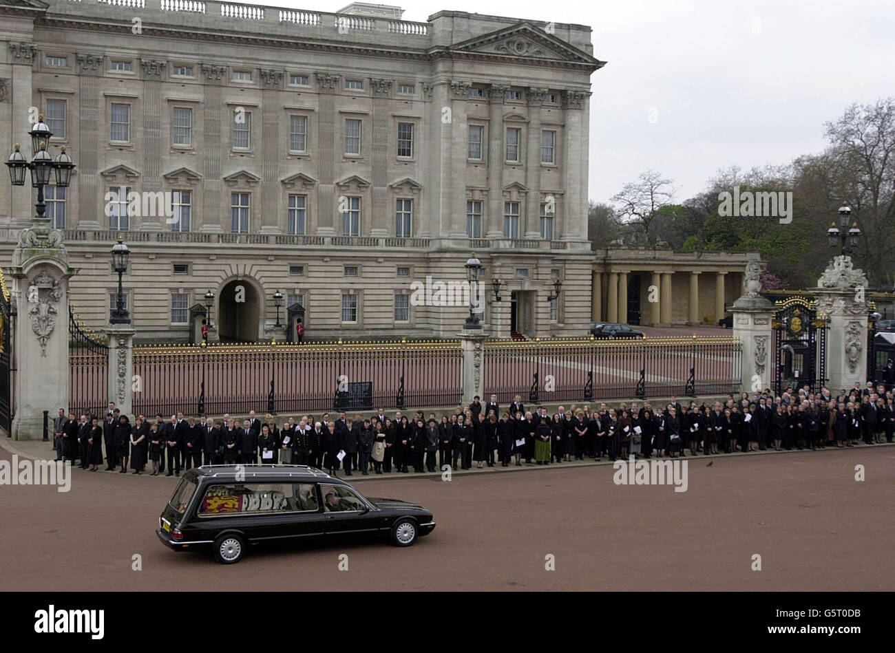 Die Mitarbeiter am Buckingham Palace beobachten den Sarg von Queen Elizabeth, die Queen Mother wird vorbeigefahren, bevor sie zur Westminister Abbey für ihr Begräbnis gebracht wird. Stockfoto