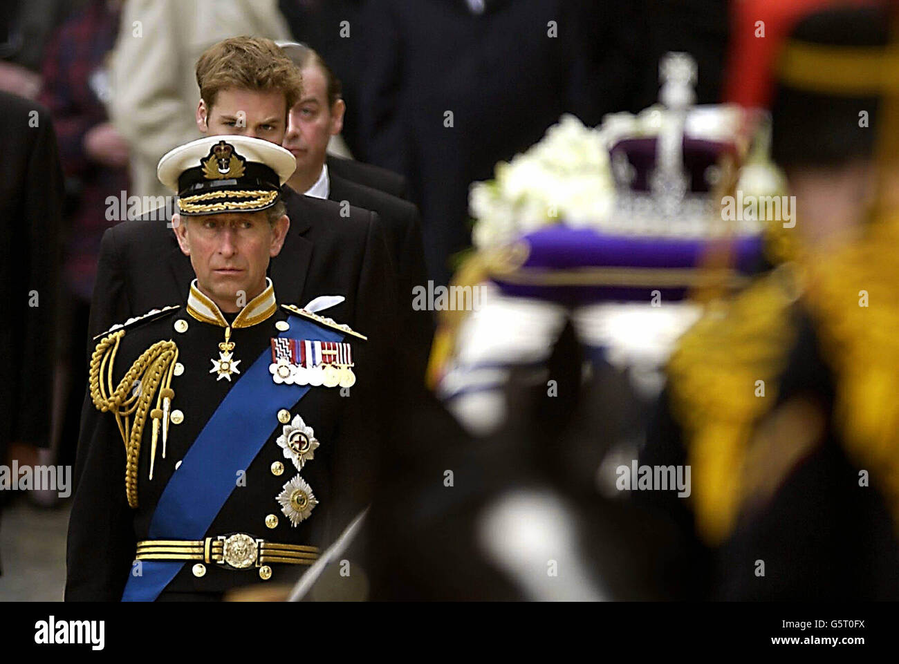 Der Prinz von Wales schaut auf den Sarg der Königin Mutter, der mit einem Waffenwagen aus der Westminster Hall in London kommt, für die Beerdigungszeremonie in der Westminster Abbey. Nach dem Gottesdienst wird die Qeen-Mutter im Schloss Windsor beigesetzt. Stockfoto
