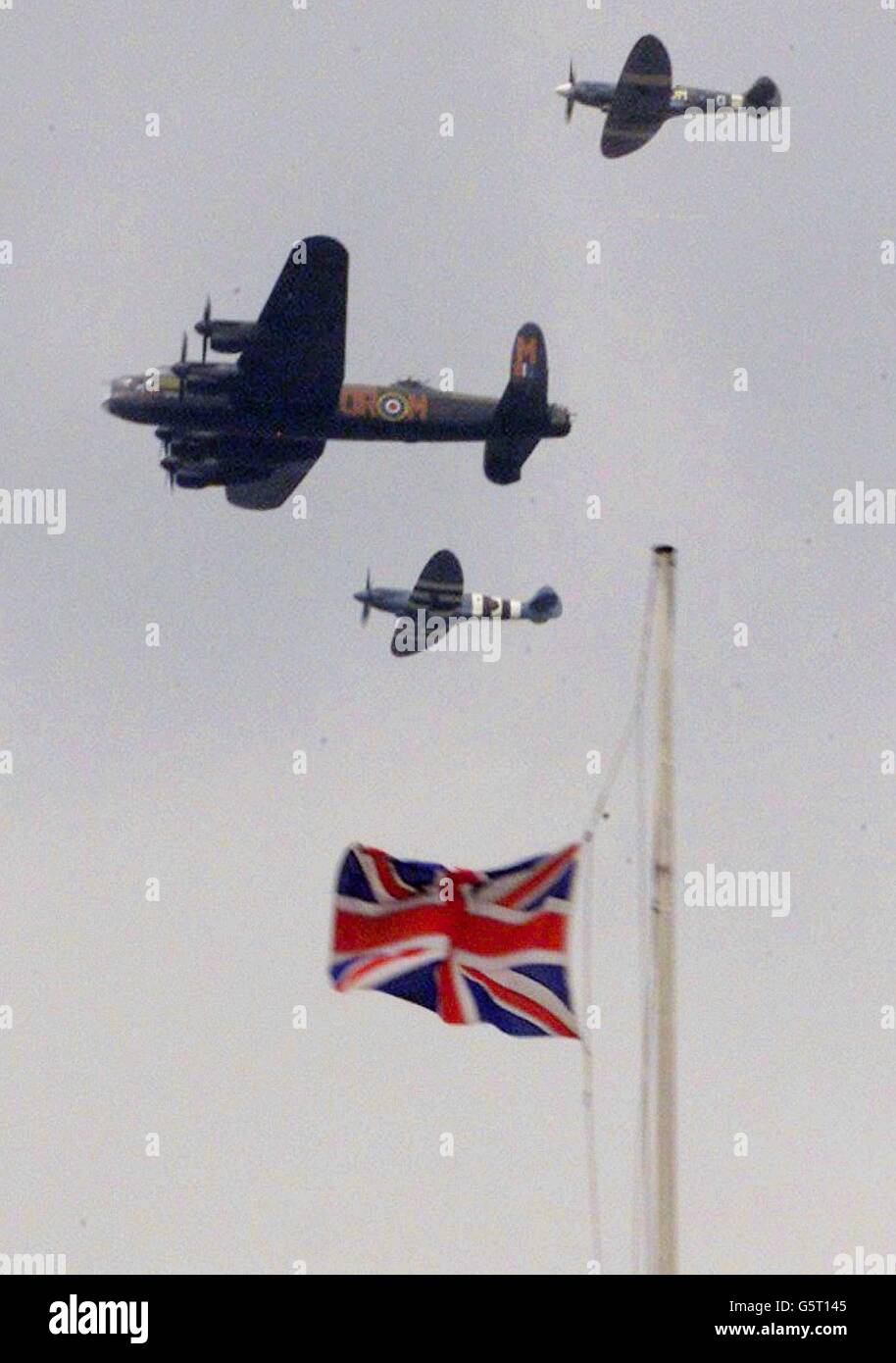 Der Flug der Royal Air Force zur Schlacht von Großbritannien, bestehend aus einem Lancaster-Bomber aus dem Zweiten Weltkrieg, einem Center und zwei Spitfire-Kämpfern, passiert nach der Beerdigung der Queen Mother in der Westminster Abbey mit halbem Stab die Unionsflagge auf dem Finanzgebäude in London. Stockfoto