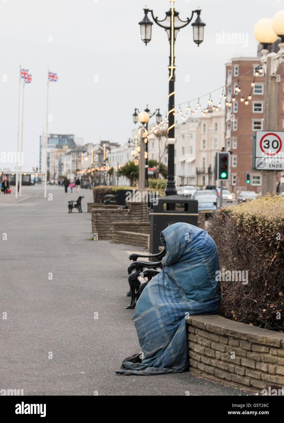 Kalten Obdachloser eingewickelt in Straße warm zu halten Stockfoto