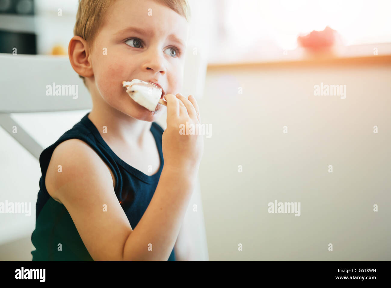 Schönes Kind Zipfelbildung Eis im Wohnzimmer Stockfoto