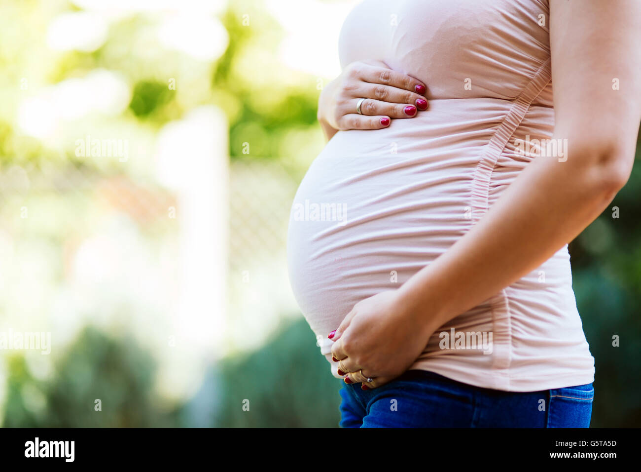 Schöne schwangere Frau Bauch im Freien halten Stockfoto