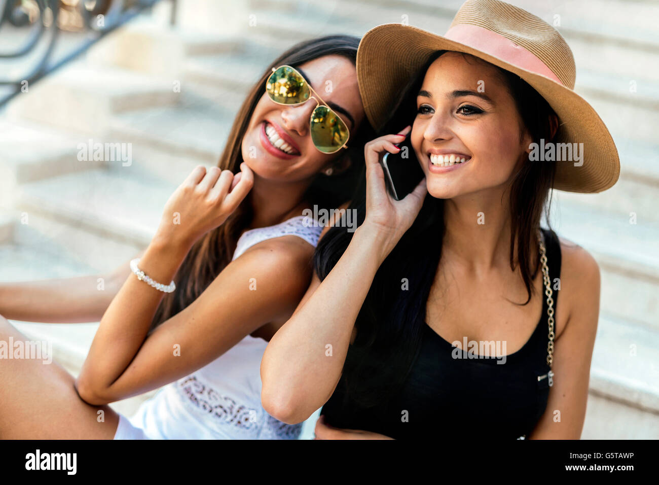 Fröhliche Frauen reden am Telefon im Sommer Stockfoto
