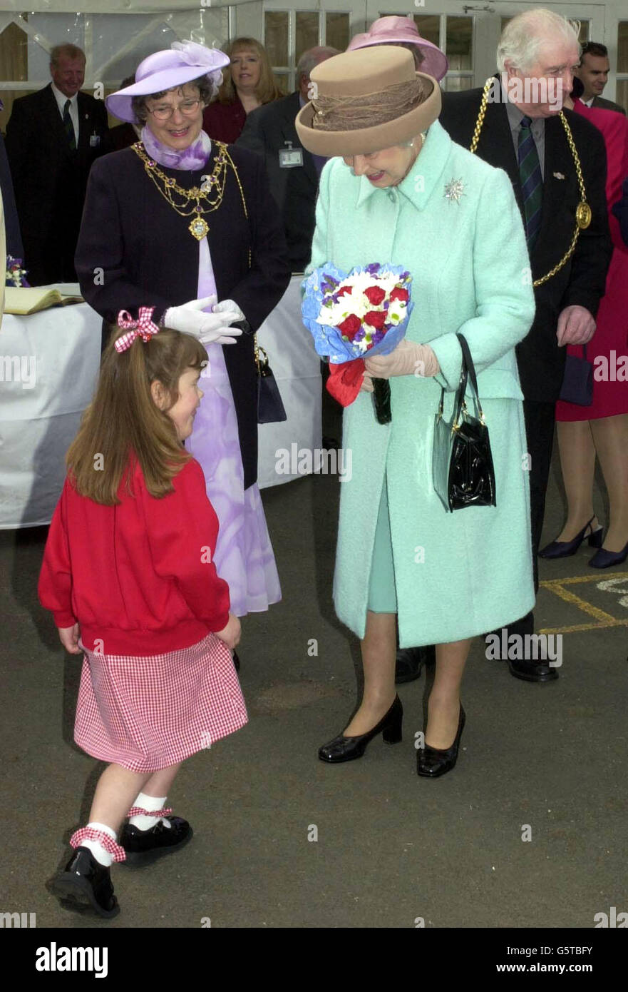 Katie Meehan, sechs Jahre alt, schenkte der Königin Blumen während ihres Besuchs in der St. Josephs RC Primary School, Jarrow, Tyne und Wear. Katie wird gerade operieren, um ihr Gesicht wieder aufzubauen. Die Königin kam in Sunderland auf der zweiten Etappe ihrer landesweiten Golden Jubilee *..Tour an. Begleitet vom Herzog von Edinburgh reiste sie über Nacht mit dem Royal Train in den Nordosten. Stockfoto