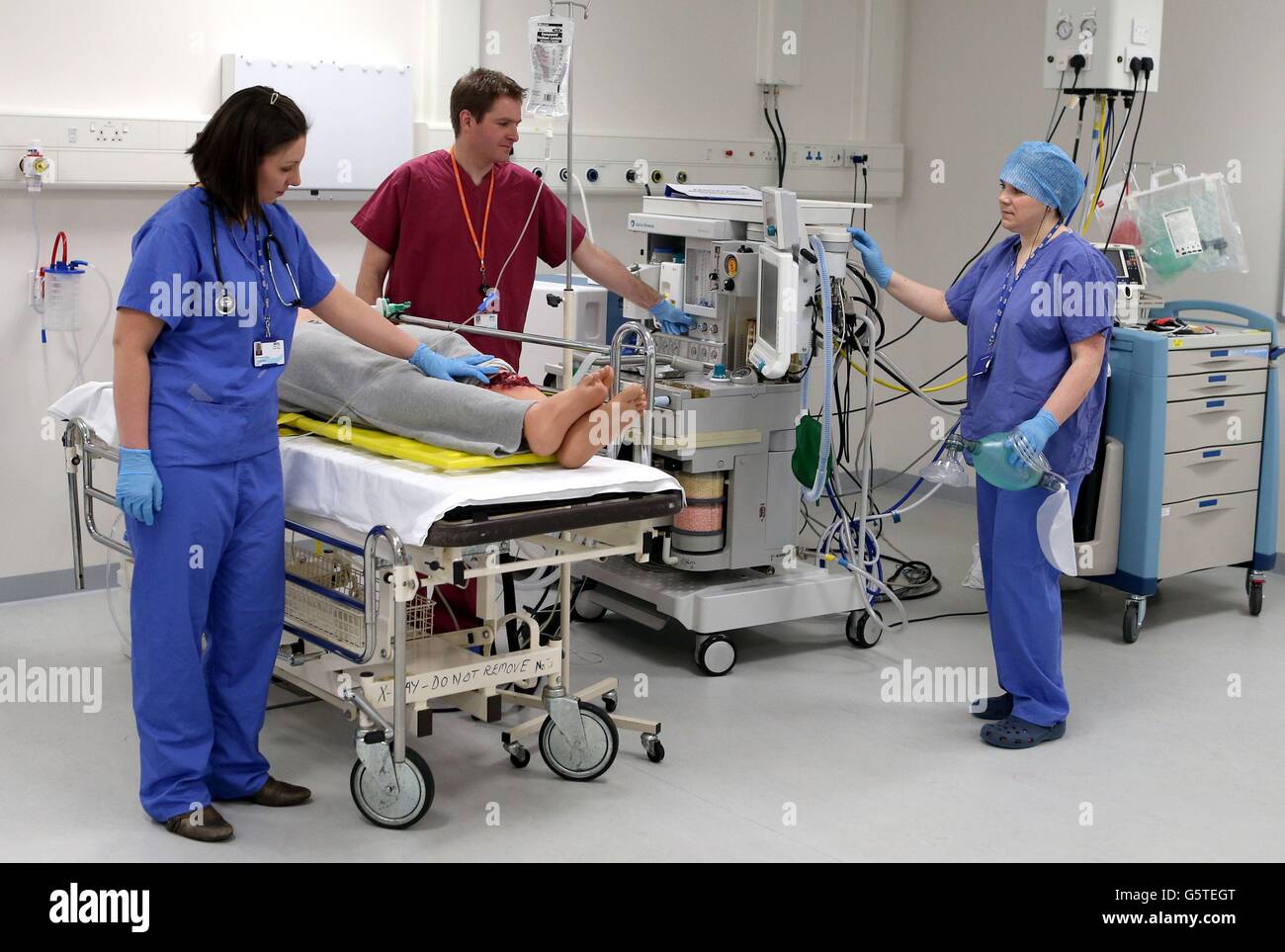 Der Roboterpatient 'Stan' wird von der Anästhesistin Dr. Donna Fraser (links, Registrar Dr. Stephen Hickey und Assistenzanästhesistin Alison Neilands (rechts) bei einem Besuch des Scottish Clinical Simulation Center im Forth Valley Royal Hospital von Gesundheitsminister Alex Neil bearbeitet. Stockfoto