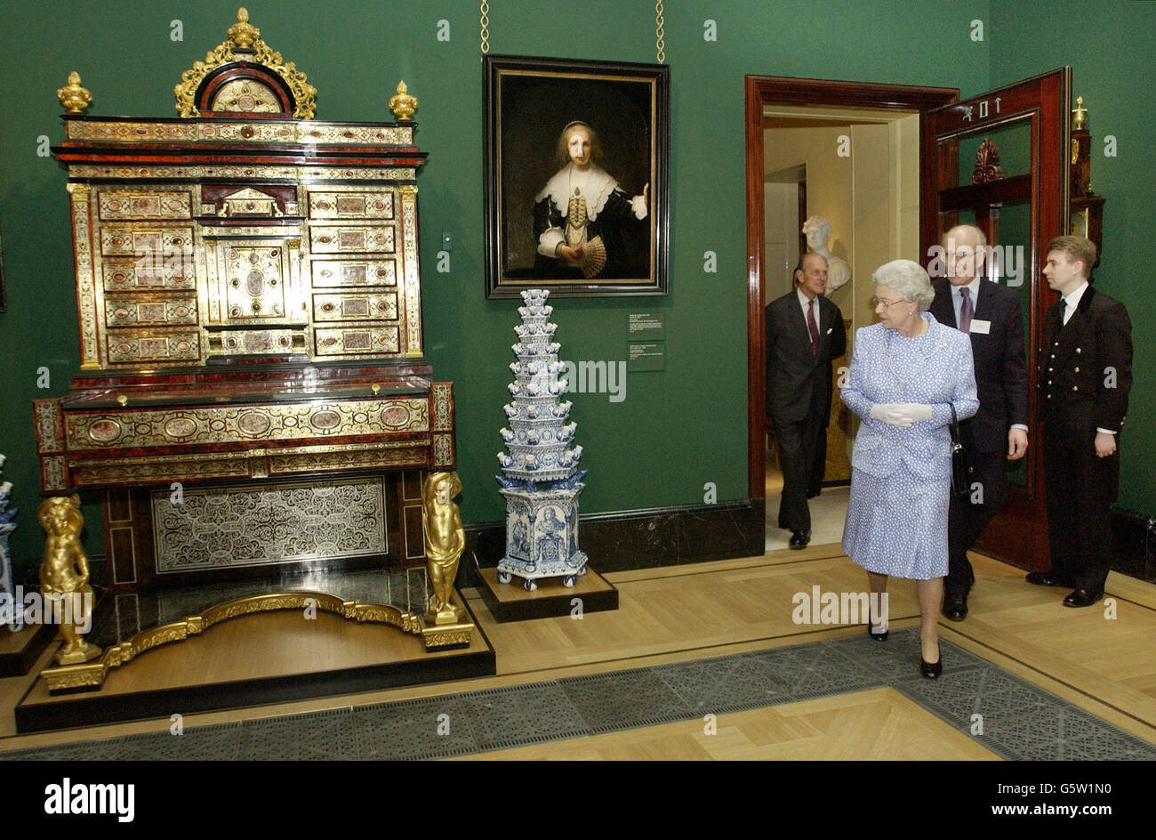 Queen Elizabeth II. Blickt auf einen kürzlich restaurierten Rembrandt, 'Agatha Bas', und ein Boulle-Secretaire-Kabinett aus dem Jahr 1700, das in der neu erweiterten Queen's Gallery im Buckingham Palace, London, ausgestellt ist. *110603*die britische Königin Elizabeth II. Zeigt einen kürzlich restaurierten Rembrandt, 'Agatha Bas', und ein Boulle-Secretaire-Kabinett aus dem Jahr 1700, das in der Queen's Gallery im Buckingham Palace, London, zu sehen ist, Das am Mittwoch, den 11. Juni 2003, zum Gewinner des Gallery of the Year Award bei den Royal Fine Art Commission Trust/British Sky Broadcasting Building of the Year Awards ernannt wurde. Stockfoto