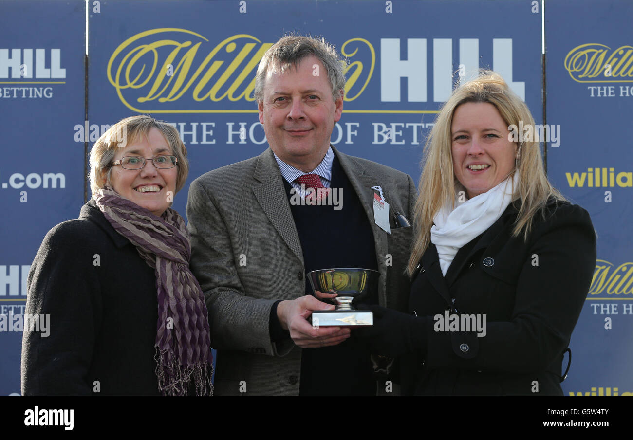 Die Besitzer von Carruthers aus der Oaksey-Partnerschaft mit Jennie Prest von William Hill (rechts), nachdem sie den William West Wales National während des William Hill Welsh Champion Hurdle Day auf der Ffos Las Racecourse in Carmarthenshire gewonnen hatten. Stockfoto