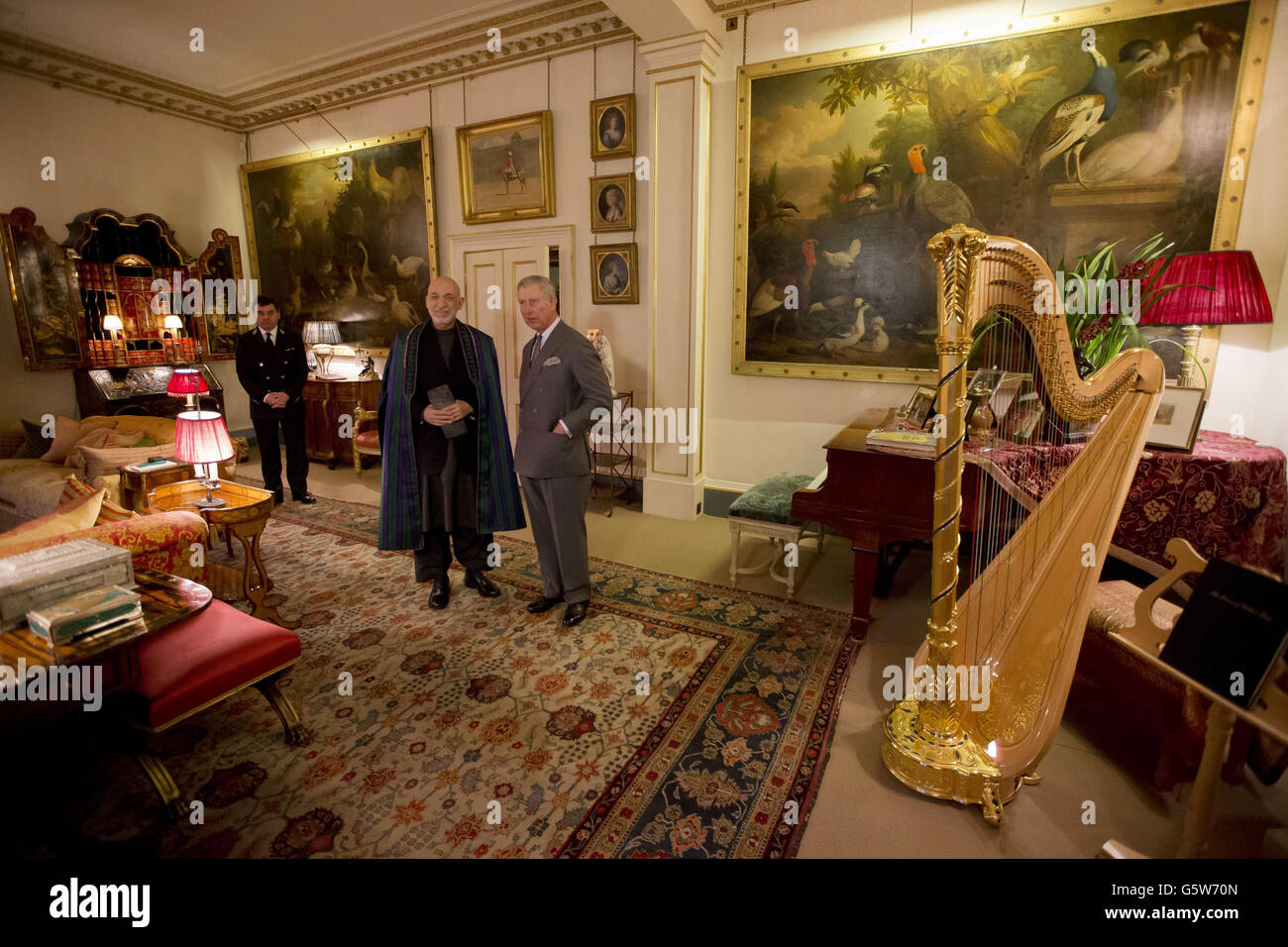 Der Prinz von Wales (rechts) und der afghanische Präsident Hamid Karzai halten vor Medienkameras inne, nachdem er zu ihrem Treffen im Clarence House in London hereinkam. Stockfoto