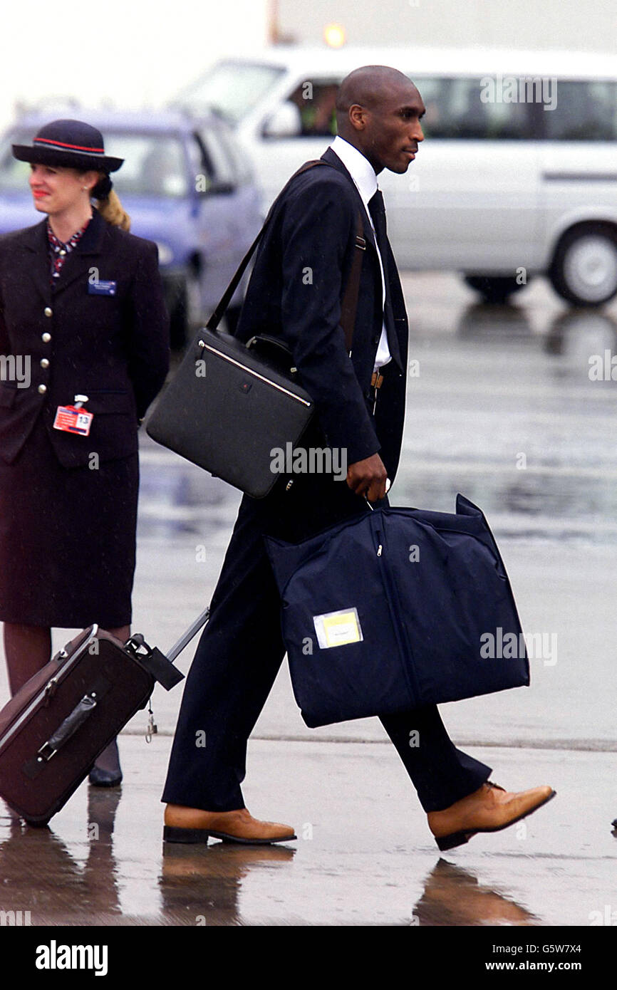 England Verteidiger Sol Campbell am Luton Airport, zu Fuß zu den British Airways Boeing 777 Flugzeuge, die sie nach Dubai bringt, wo sie ihre letzten Vorbereitungen vor der WM zu beenden. * Kapitän David Beckham gab Manager Sven Goran Eriksson einen Auftrieb, indem er sich selbst zu einem 95% bestimmten Starter für das erste Wettbewerbsspiel der Seite im Finale erklärte. Stockfoto England Verteidiger Sol Campbell am Luton Airport, zu Fuß zu den British Airways Boeing 777 Flugzeuge, die sie nach Dubai bringt, wo sie ihre letzten Vorbereitungen vor der WM zu beenden. * Kapitän David Beckham gab Manager Sven Goran Eriksson einen Auftrieb, indem er sich selbst zu einem 95% bestimmten Starter für das erste Wettbewerbsspiel der Seite im Finale erklärte. Stockfoto