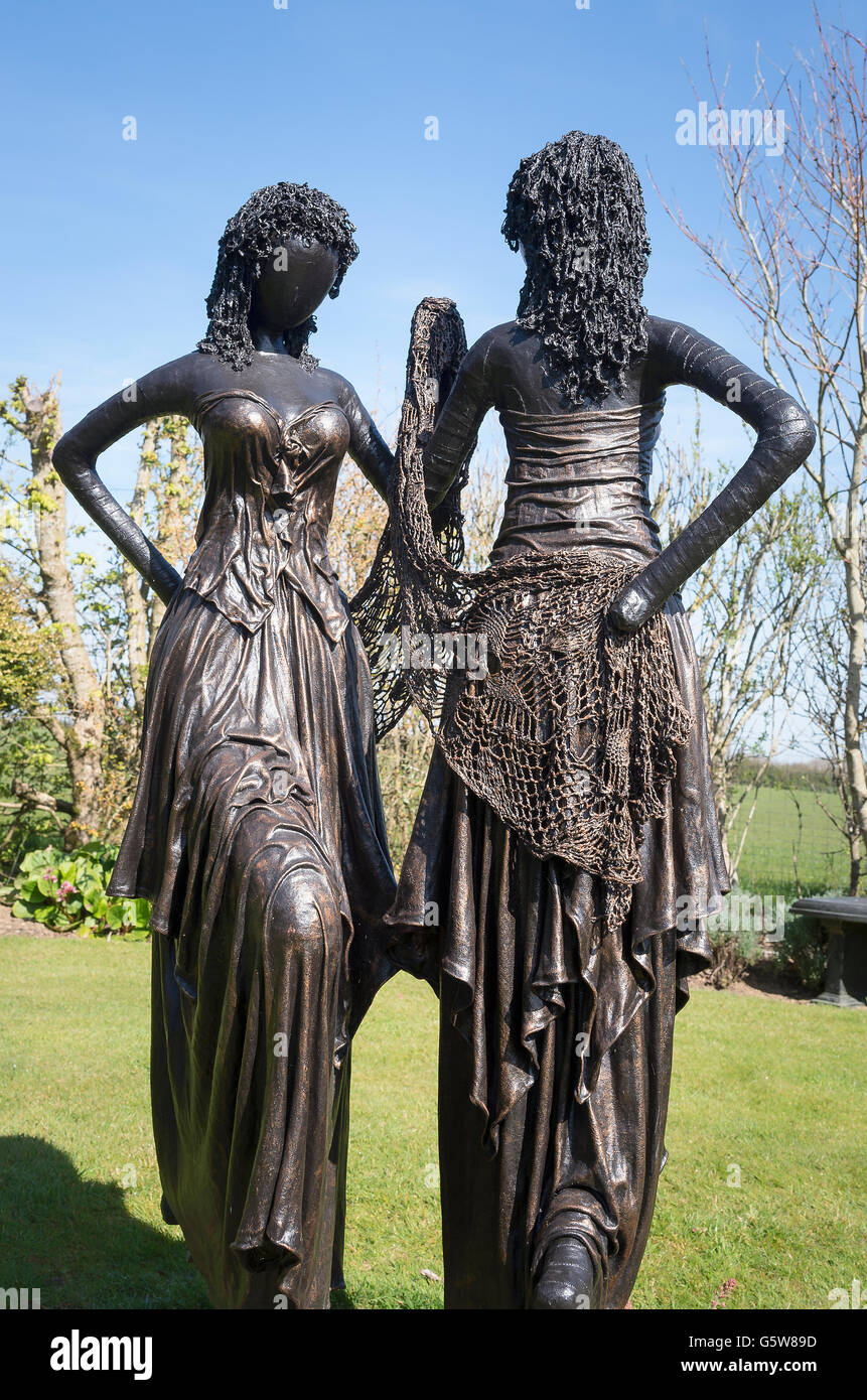 Garten Skulptur mit zwei jungen Damen in Party Kleider in einer kleinen kornischen Gardenot in der Nähe von Truro Stockfoto