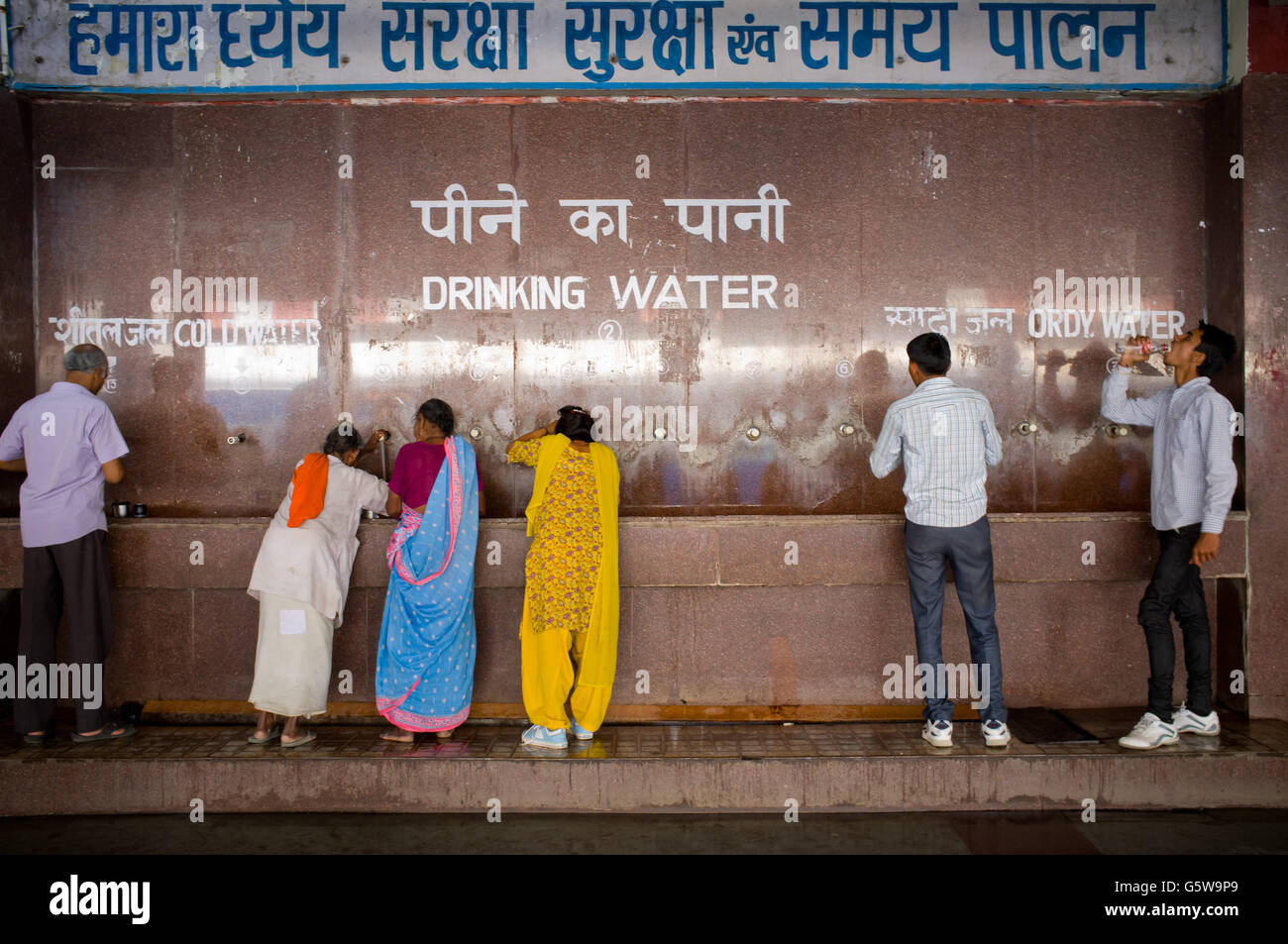 Trinkt man Wasser in eine Quelle von Haridwar Bahnhof in Indien. Stockfoto