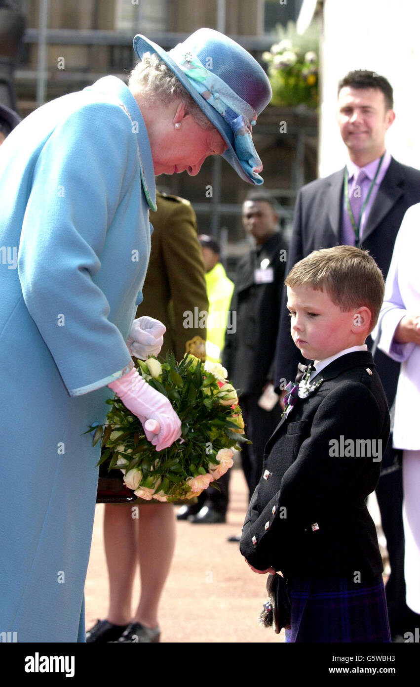 Die britische Königin Elizabeth II. Wird von Michael Blair aus Bargeddie bei ihrer Ankunft am George Square in Glasgow mit posey überreicht. Stockfoto