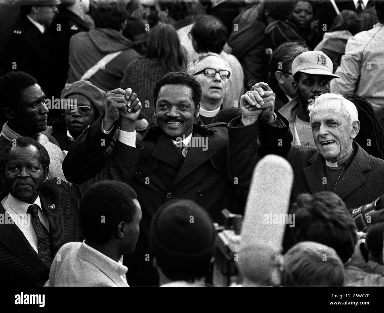 8. OKTOBER: An diesem Tag im Jahr 1941 wurde Jesse Jackson geboren. DER US-Demokrat und Bürgerrechtler Rev. Jesse Jackson verbindet die Hände mit Oliver Tambo (links), dem Präsidenten des Afrikanischen Nationalrats, und Bischof Trevor Huddleston (rechts) bei seiner Ankunft auf dem Trafalgar Square, nachdem er dort im Rahmen einer Anti-Apartheid-Kundgebung marschiert war. Stockfoto