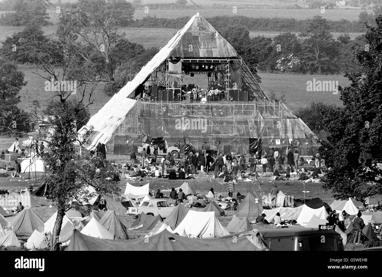 Eine Plastik-Pyramide schützt das Dais und wird von kleineren Zelten der Teilnehmer auf der würdigen Farm Pilton für das Glastonbury Festival umgeben. Stockfoto