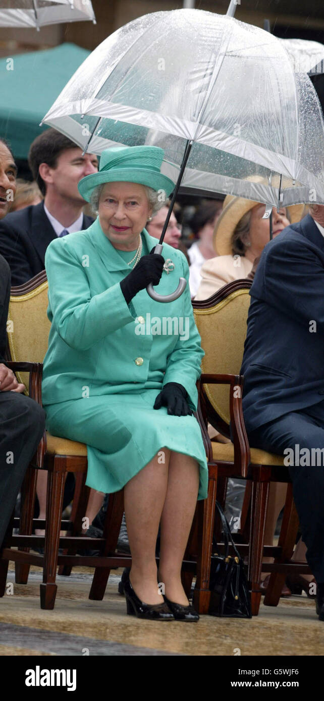 Königin Elizabeth II. Schützt sich vor Regen während ihres Besuchs in Slough, im Rahmen der Feierlichkeiten zum Goldenen Jubiläum. Stockfoto