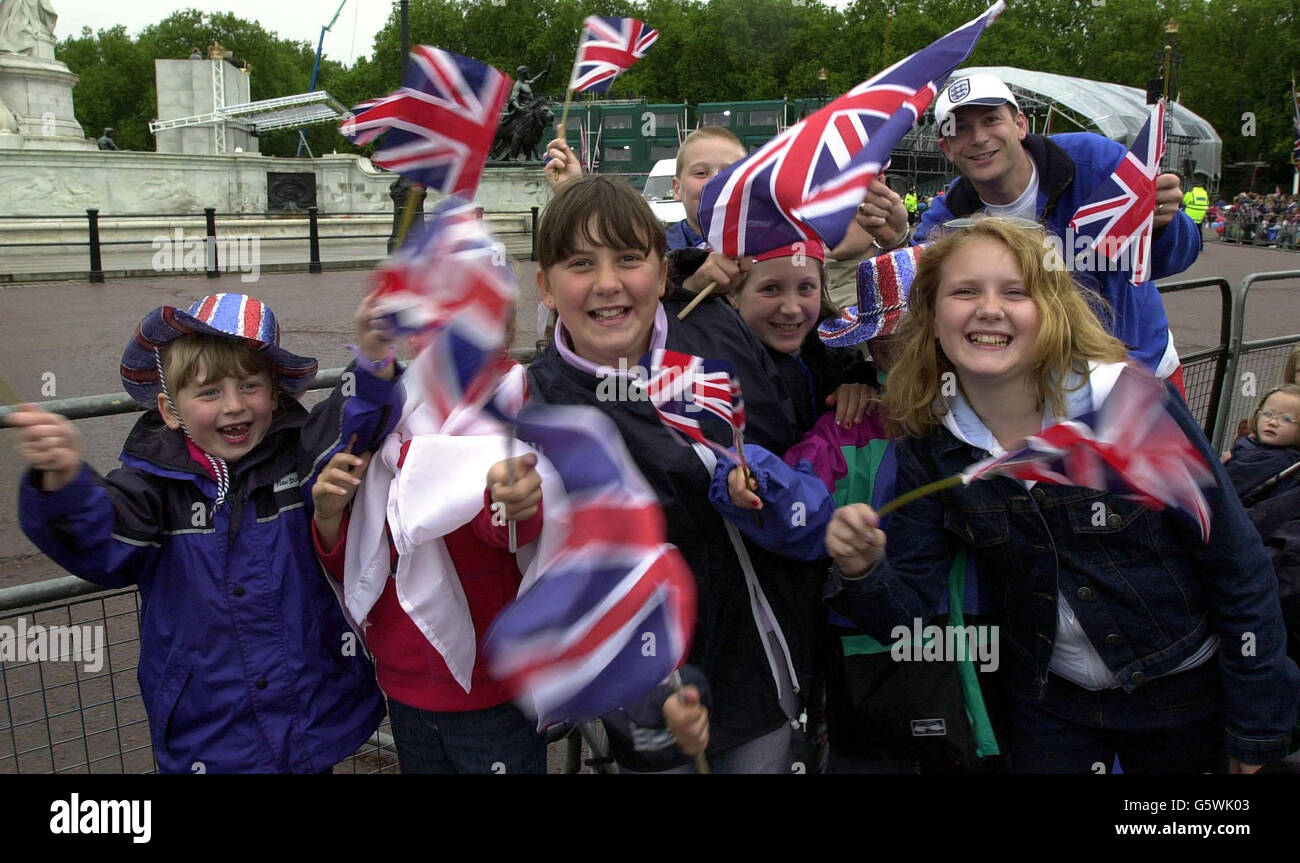 Kinder schwingen ihre Union Jack Flaggen vor dem Buckingham Palace. Die britische Königin Elizabeth II. Und der Herzog von Edinburgh verlassen den Buckingham Palace in einem Gold State Coach für einen Dankgottesdienst an der St. Paul's Cathedral. * .... vor der Rückkehr zu einer Parade in der Mall am letzten Tag des Golden Jubilee Bank Holiday Wochenende zu sehen. Stockfoto