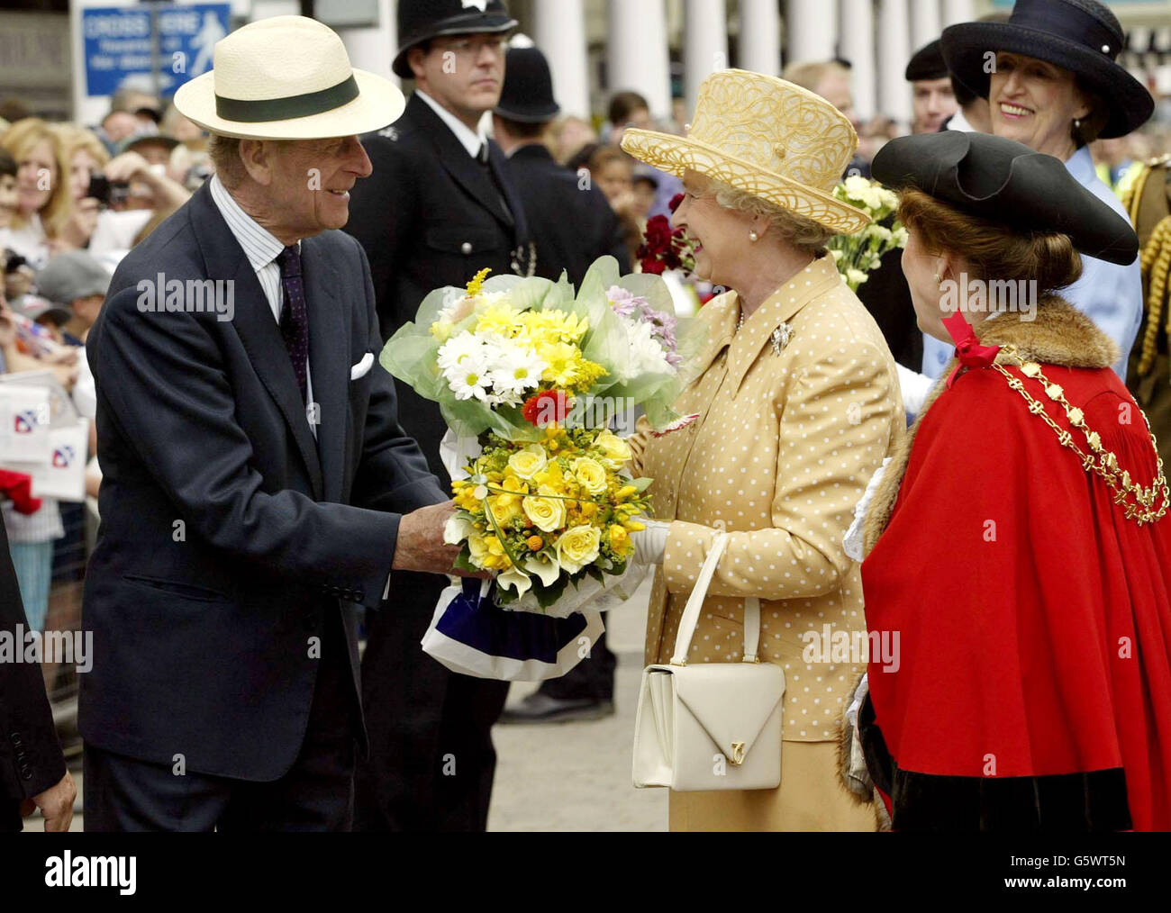 Königin Elizabeth II. Wird vom Herzog von Edinburgh Blumen überreicht, wie sie von den wohlhabenden Menschen im Stadtzentrum von Uxbridge während ihres Golden Jubilee-Besuches in Middlesex empfangen werden. Stockfoto