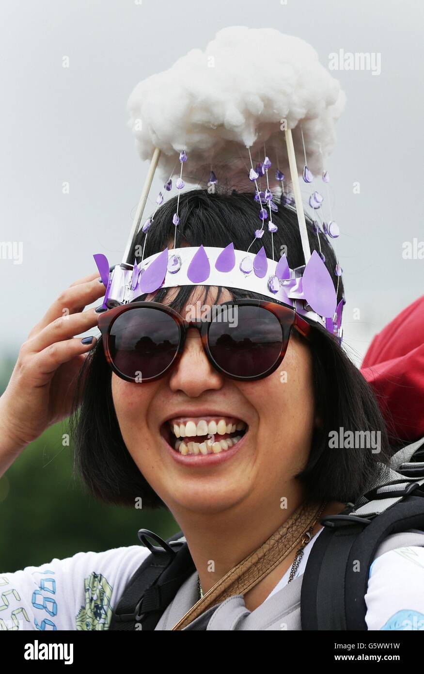 Bruna Magor, aus London, kommt einen Hut Purple Rain Prinz Tribut für das Glastonbury Festival am Standort würdig Farm, Somerset, wo schwere Regen über einen längeren Zeitraum isoliert Überschwemmungen verursacht hat und schlammigen Feldern. Stockfoto