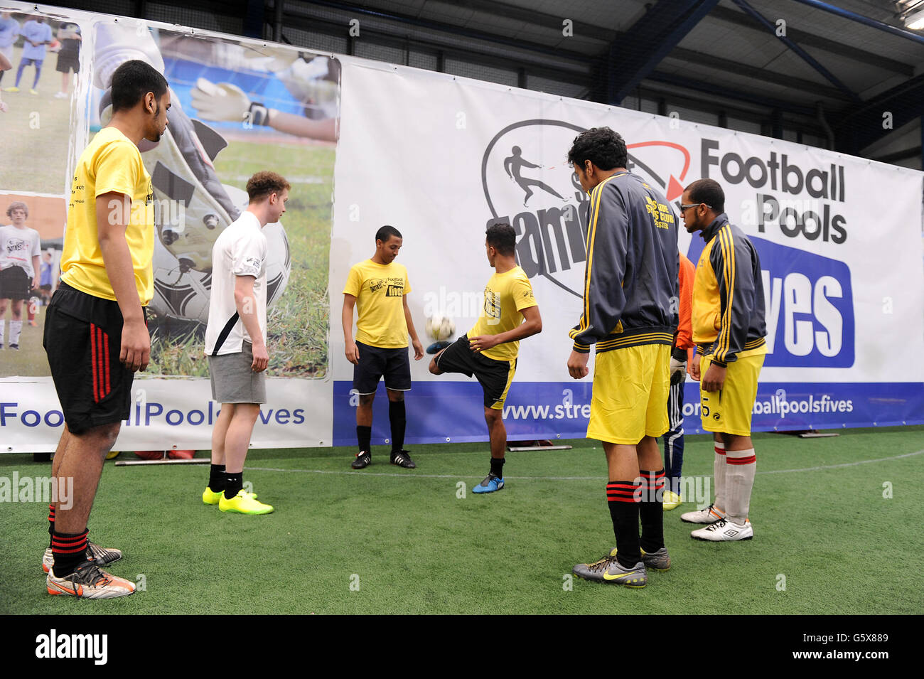 Spieler mit Freestyle-Fußballer John Whetton beim Start des StreetGames Football Pools Fives Festival in Manchester. Stockfoto