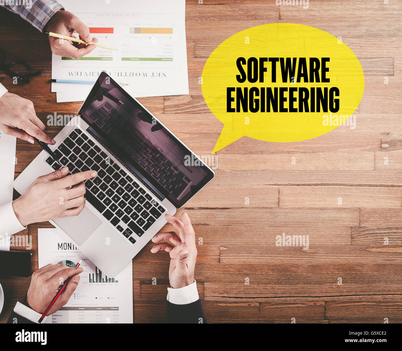 BUSINESS-TEAMS ARBEITEN IM BÜRO MIT SOFTWARE-ENGINEERING-REDE AUF SCHREIBTISCH-BLASE Stockfoto