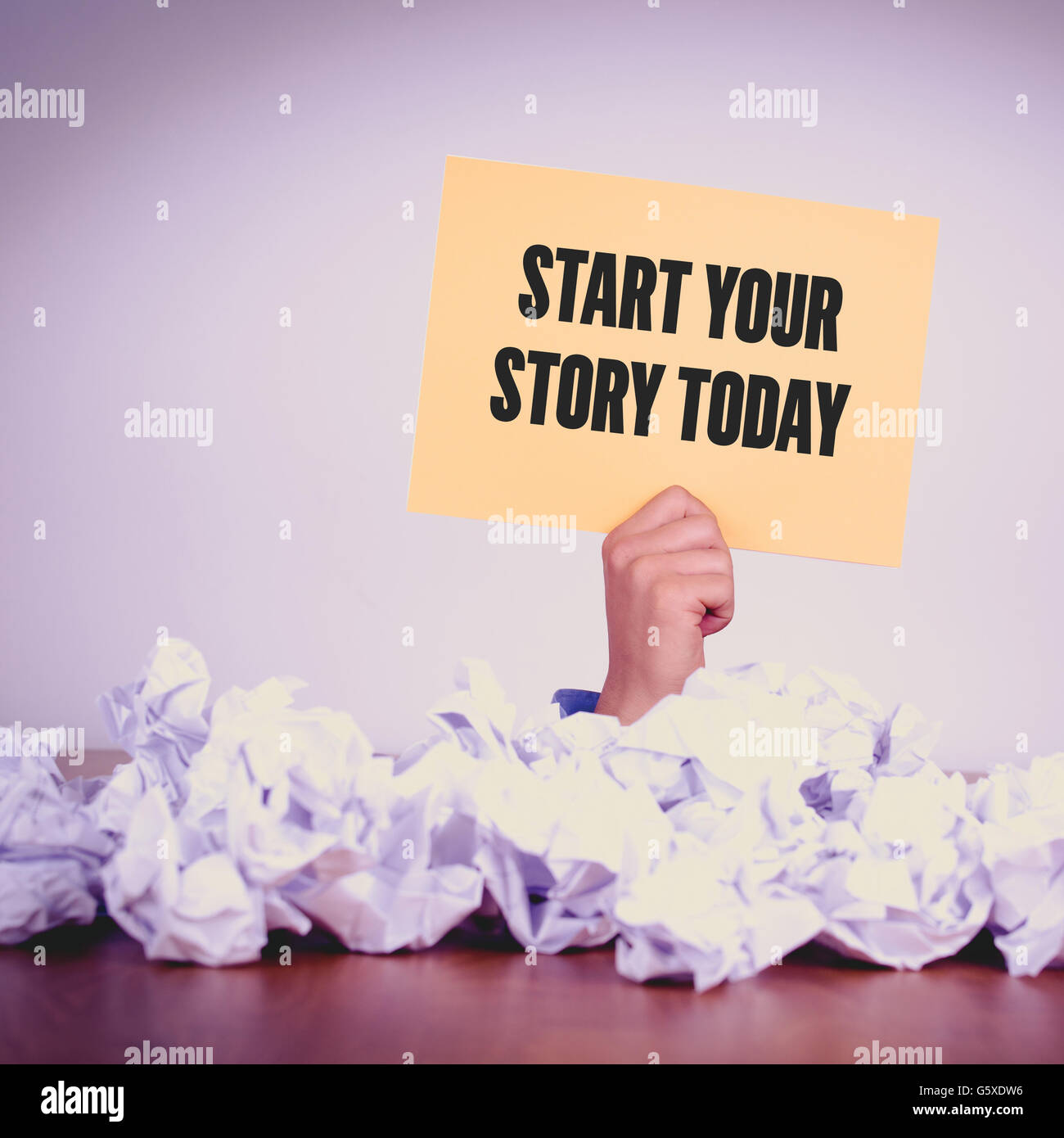 HAND MIT GELBEN PAPIER MIT BEGINN IHRER GESCHICHTE TODAYCONCEPT Stockfoto