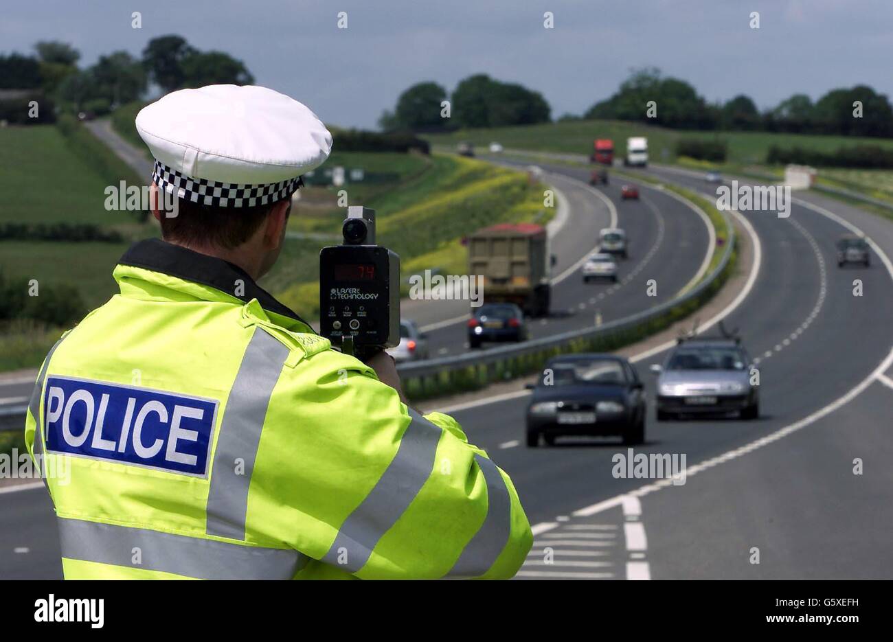 Sgt Paul Moor von der Essex Traffic Police benutzt eine Lasergeschwindigkeitspistole auf der neuen Strecke der A130 zwischen Chelmsford und Southend. Vierzig Autofahrer, die über 100 mph auf der neuen Straße gefahren sind, erscheinen bei einer Sondergerichtsverhandlung am Witham Magistrate Court. 01/09/04: Nach neuen Regierungsvorschlägen könnten Fahrer wegen einer bloßen Übertretung der Geschwindigkeitsbegrenzungen ermäßigte Geldstrafen erhalten, mit Strafen zwischen 40 und zwei Strafpunkten für weniger schwere Straftaten und bis zu 100 und sechs Punkten für schwerere Straftaten. Die Konsultation, die später von Verkehrsminister Alistair Darling angekündigt wurde, schließt die Polizei ein Stockfoto