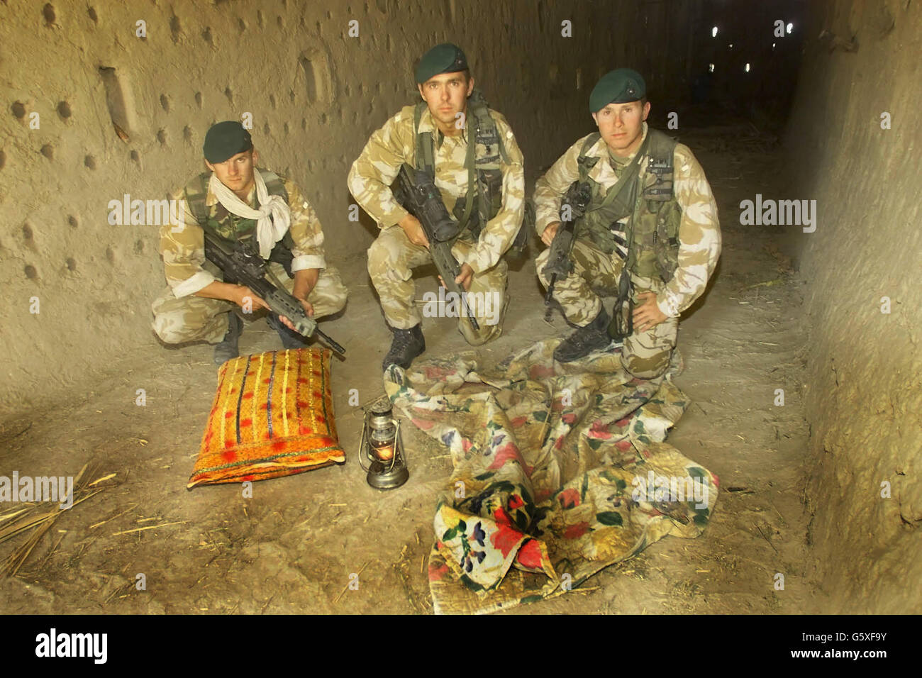 Britische Militärangehörige Marine Dean Cubitt (links), Corporal John Andrews (Mitte) und Vizeleutnant David Spink in der Lehmziegelscheune im Dorf Atalay 50 Meilen nordwestlich von Kandahar im Süden Afghanistans. * ... wo Royal Marines und US-Spezialeinheiten haben entdeckt, ein Cache von Waffen und Sprengstoff während eines Razzia Donnerstag, 6. Juni 2002. Die Truppen fanden Waffen, Plastikexplosivstoffe und Bombenanbaugeräte sowie Dokumente von geheimdienstlicher Bedeutung, die analysiert werden. Soldaten glauben, dass eine Person, die in der Scheune flüchtet nur wenige Momente, bevor die Truppen mit dem Hubschrauber angekommen, wie sie Stockfoto