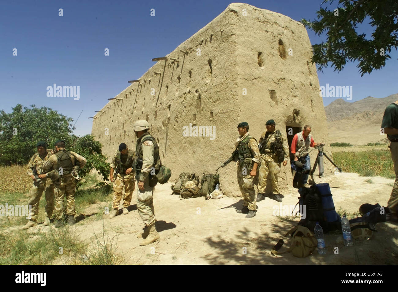 Militäraktivitäten außerhalb der Lehmziegelscheune im Dorf Atalay, 50 Meilen nordwestlich von Kandahar im Süden Afghanistans, wo Royal Marines und US-Spezialeinheiten während eines Angriffs einen Cache mit Waffen und Sprengstoffen entdeckt haben. * Truppen fanden Waffen, Plastikexplosivstoffe und Bombenanbaugeräte sowie Dokumente von geheimdienstlicher Bedeutung, die analysiert werden. Soldaten glauben, dass eine Person, die in der Scheune schlief, nur wenige Augenblicke vor der Ankunft der Truppen mit dem Hubschrauber eine noch brennende Öllampe und Bettzeug auf dem Boden vorfand. Stockfoto