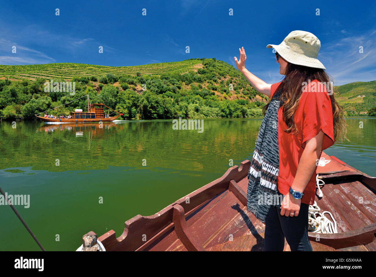 Portugal: Mädchen mit Hut in traditionellen Rabelo-Boot Gruß andere Boot am Fluss Douro Tour Stockfoto