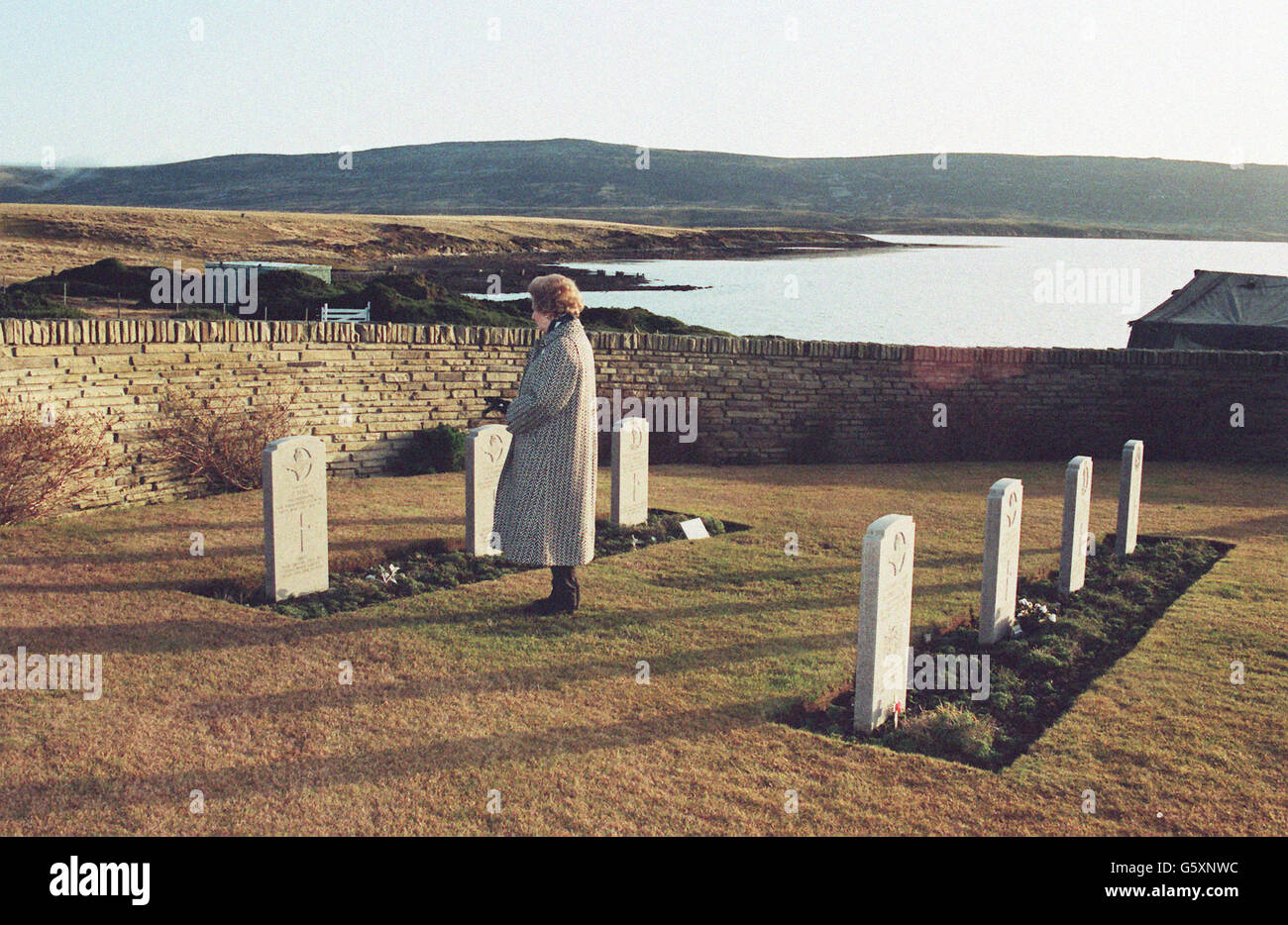 Die ehemalige britische Premierministerin Margaret Thatcher erinnert allein auf dem Friedhof von San Carlos an die Soldaten, die an diesem Ort, an dem die Invasion begann, ihr Leben verloren haben. Das Grab ganz rechts hinter Frau Thatcher ist das des Kriegshelden Colonel H Jones. Stockfoto